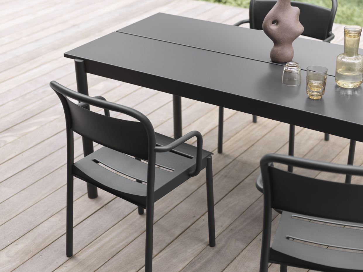 Grauer Linear Steel Outdoor Tisch (200x75 cm) mit Stühlen auf einer Holzterrasse. Gartenmöbel.