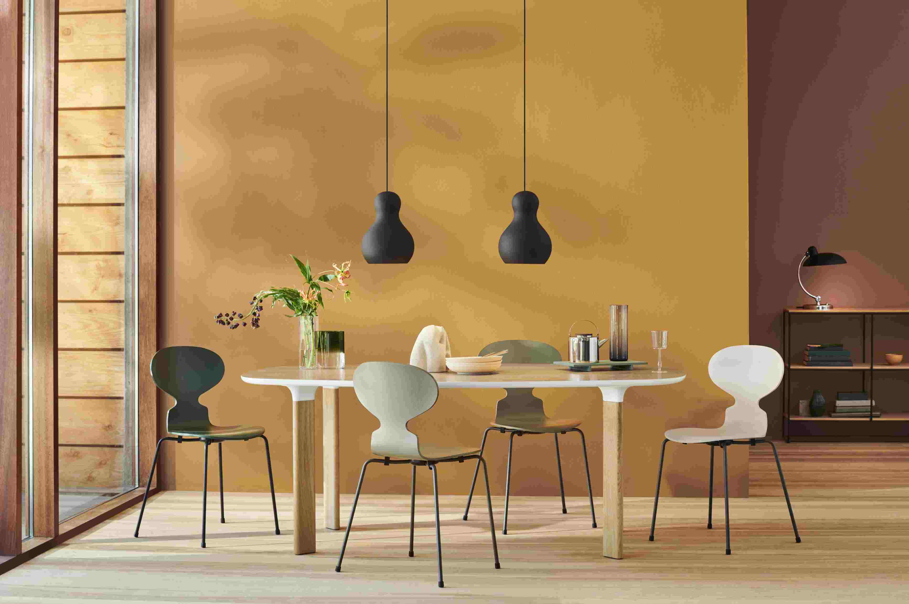 Esszimmer mit Esstisch und vier Fritz Hansen Ameise Stühlen mit vierbeinigen, schwarzen Stahlgestellen.