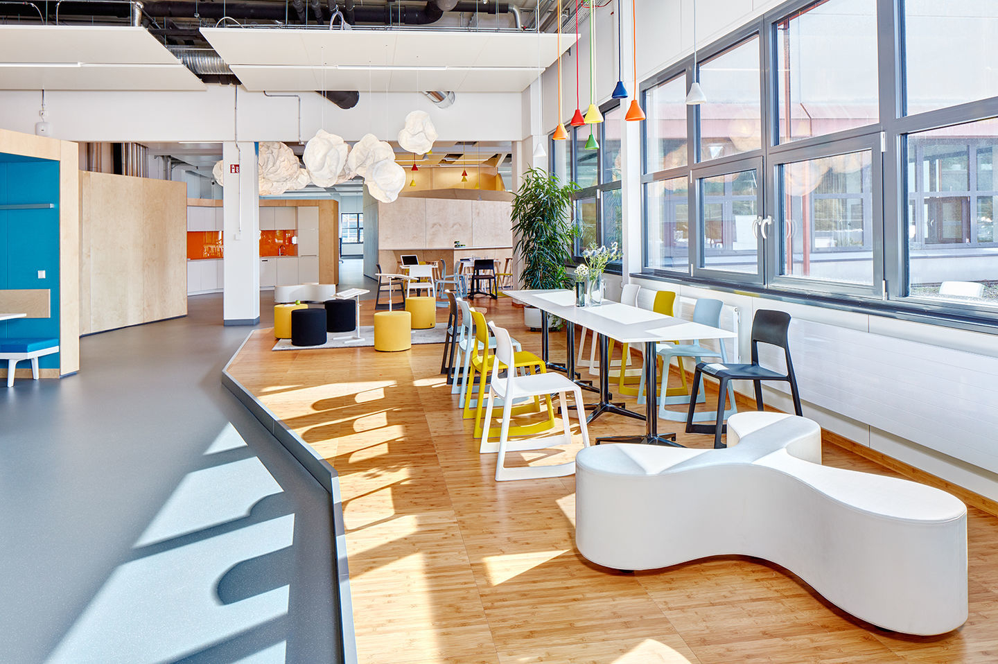 Helles Büro mit langem Tisch und bunten Vitra Tip Ton Stühlen aus Kunststoff für modernes Arbeiten.