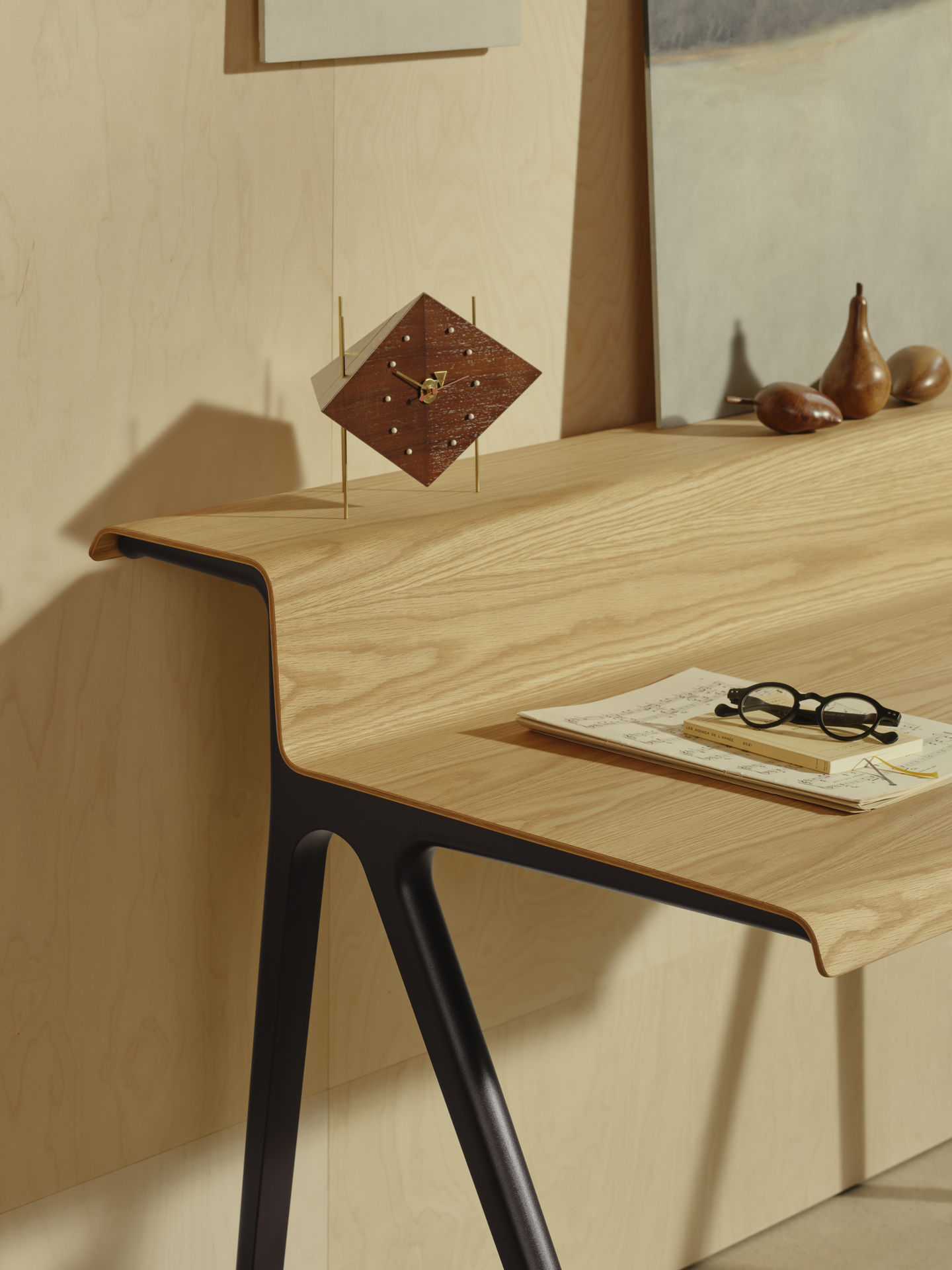 Detailaufnahme des Vitra Courier Schreibtischs mit Holzplatte und schwarzen Beinen, inklusive Accessoires.