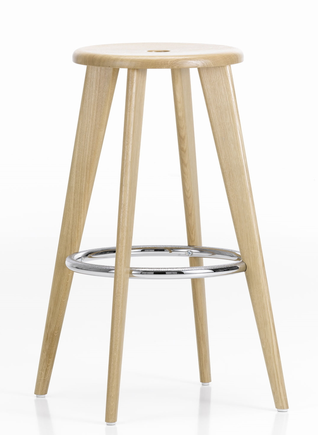 Vitra Tabouret Haut Barhocker aus Eiche natur mit Fußstütze aus Chrom vor weißem Hintergrund.
