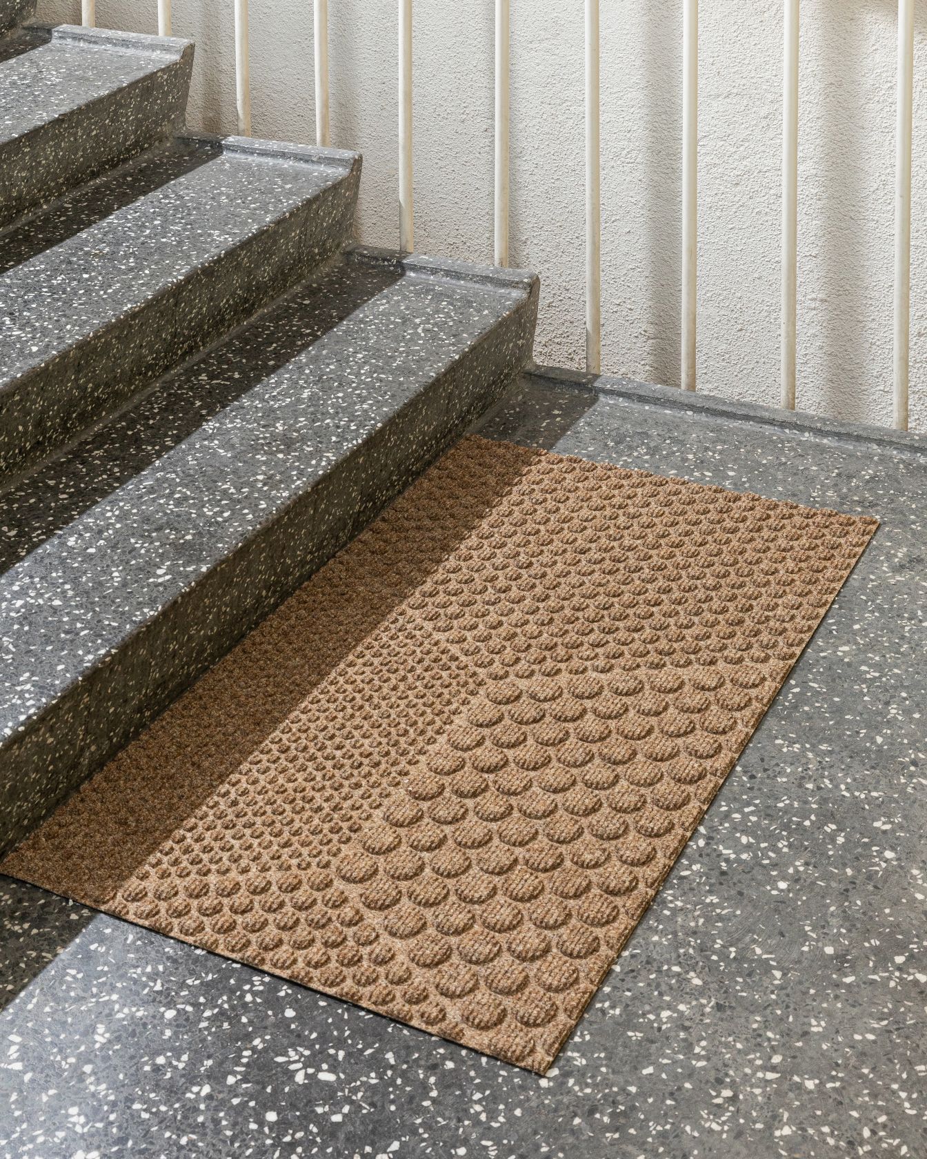 Beige Hex Fußmatte von Heymat vor einer Treppe, Detailaufnahme für den Online-Shop.