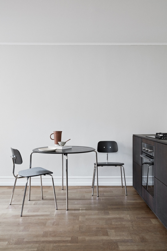 Kevi Stuhl 2060 Montana, grauer und schwarzer Designstuhl mit Stahlgestell an Esstisch in Küche.