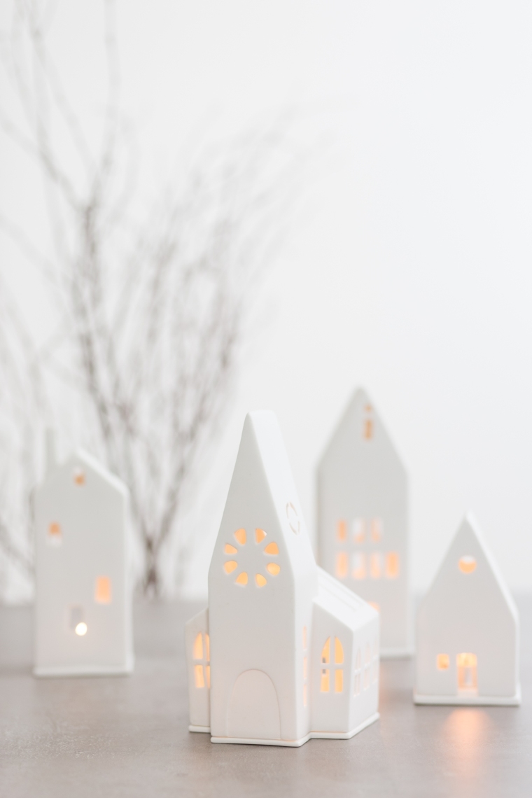 Detailaufnahme von weißen Lichthäusern, darunter eine Kirche, für stimmungsvolle Weihnachtsdekoration.