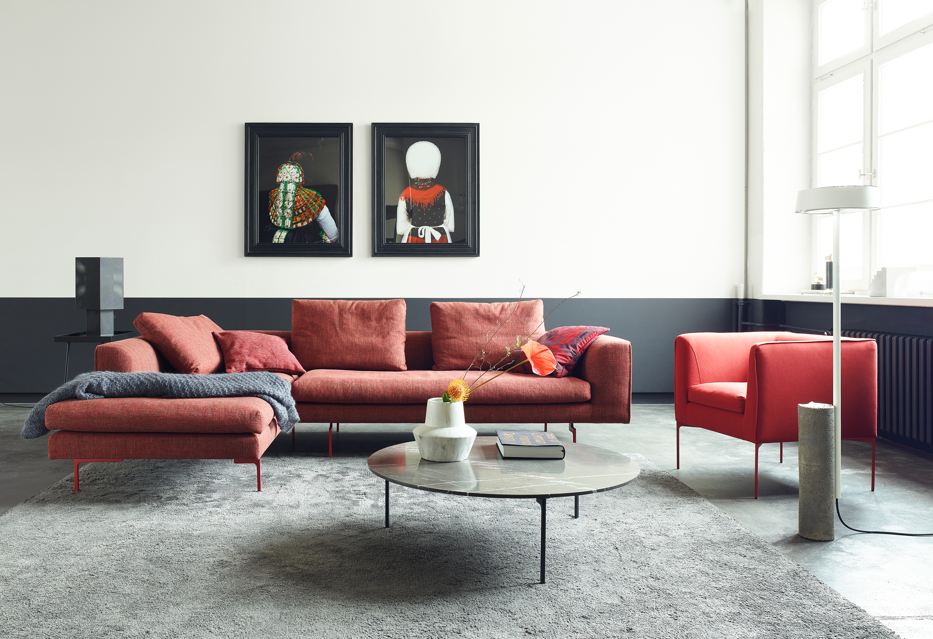 Wohnzimmer mit rotem Mell Sofa, Sessel, Teppich und Couchtisch von Cor.