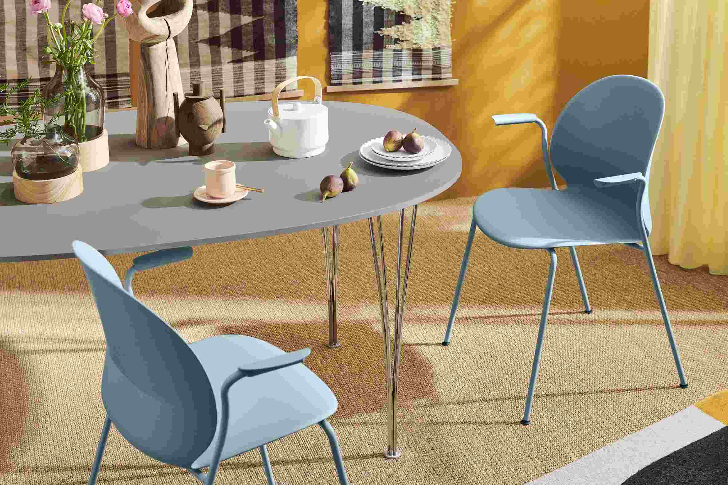 Fritz Hansen Super Elliptisch Tisch mit Teekanne, Geschirr und blauen Stühlen in einem modernem Esszimmer.