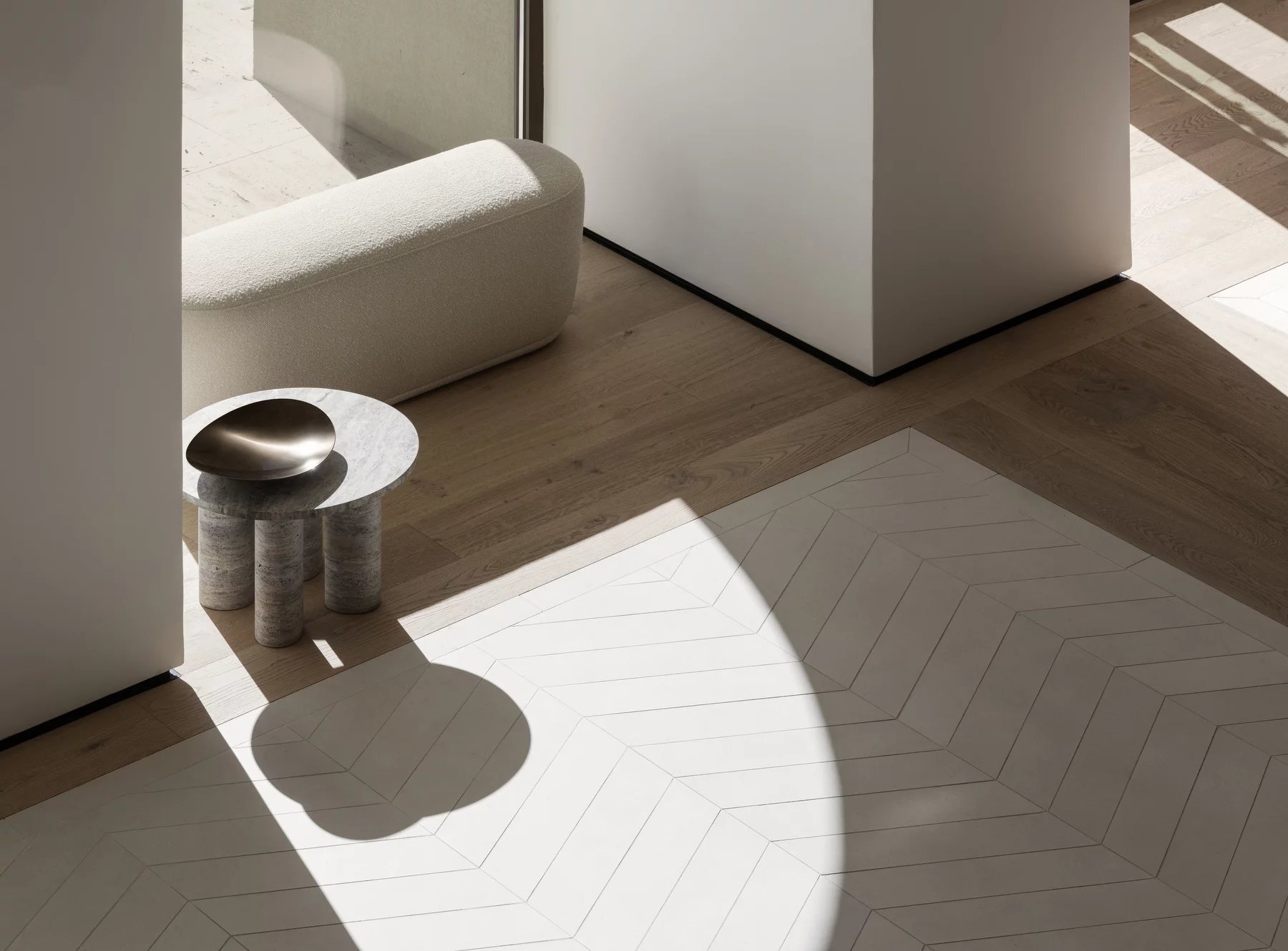 Blomus Volos Beistelltisch, runder Marmortisch mit drei Beinen und Metallschale in modernem Interieur.