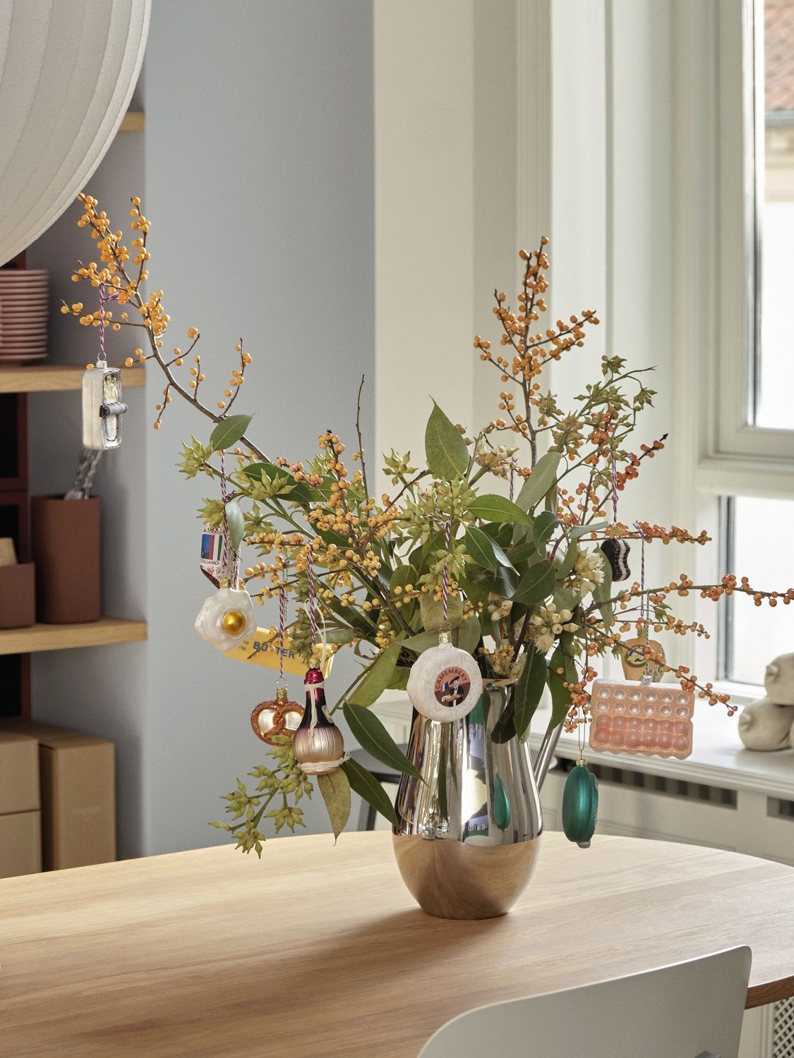Nahaufnahme des Hay Triangle Leg Table Esstisch mit Blumenvase und dekorativen Anhängern.
