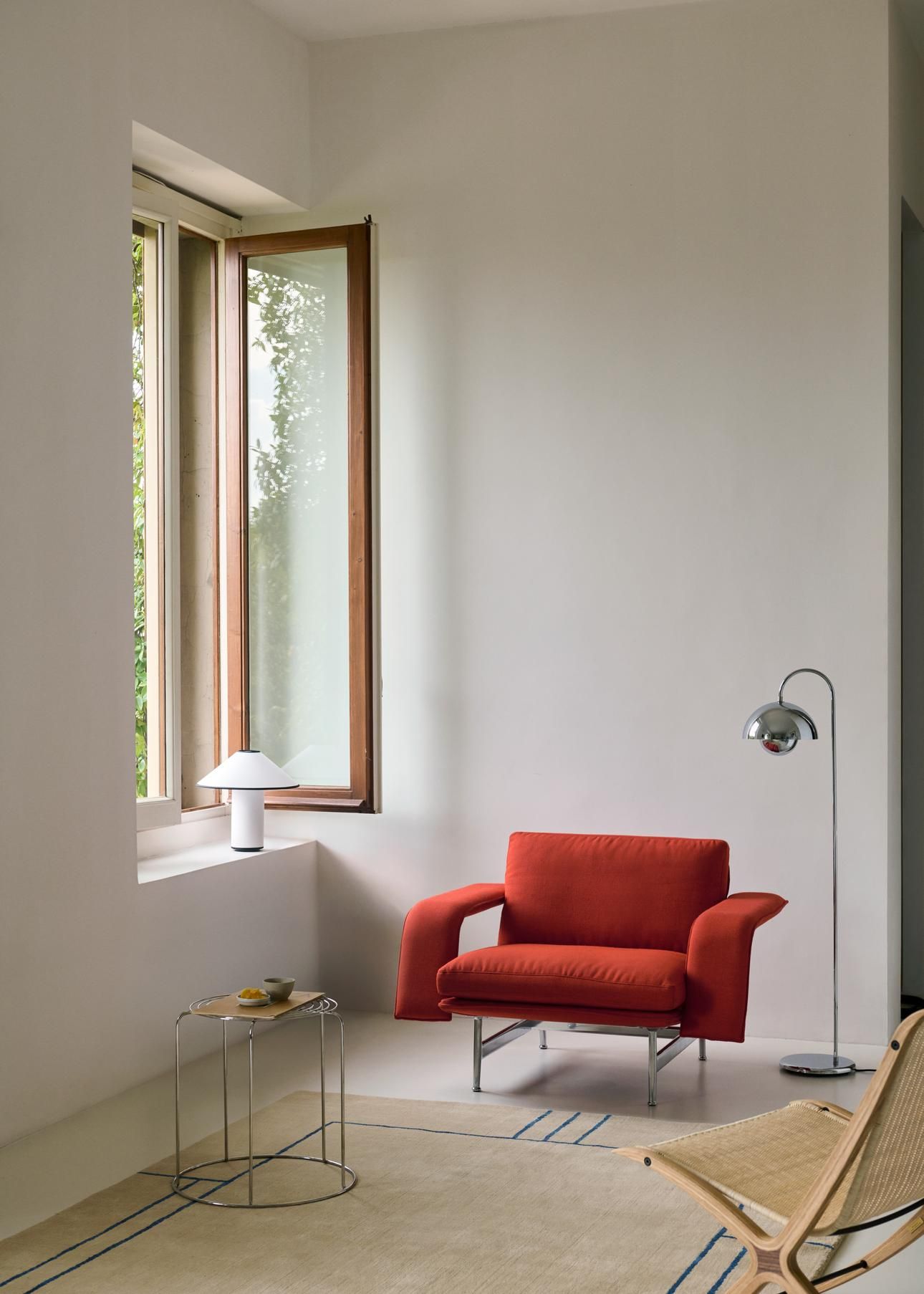 Beige Cruise Teppich von AndTradition in einem hellen Wohnzimmer mit Sessel und Stehlampe.