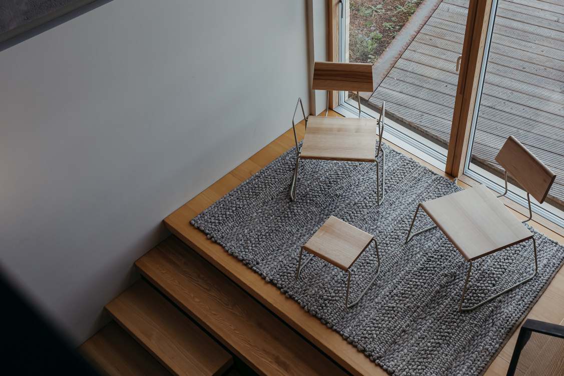 Draufsicht: D:008 Loungechair Fuchs & Habicht, Sessel und Hocker auf grauem Teppich.
