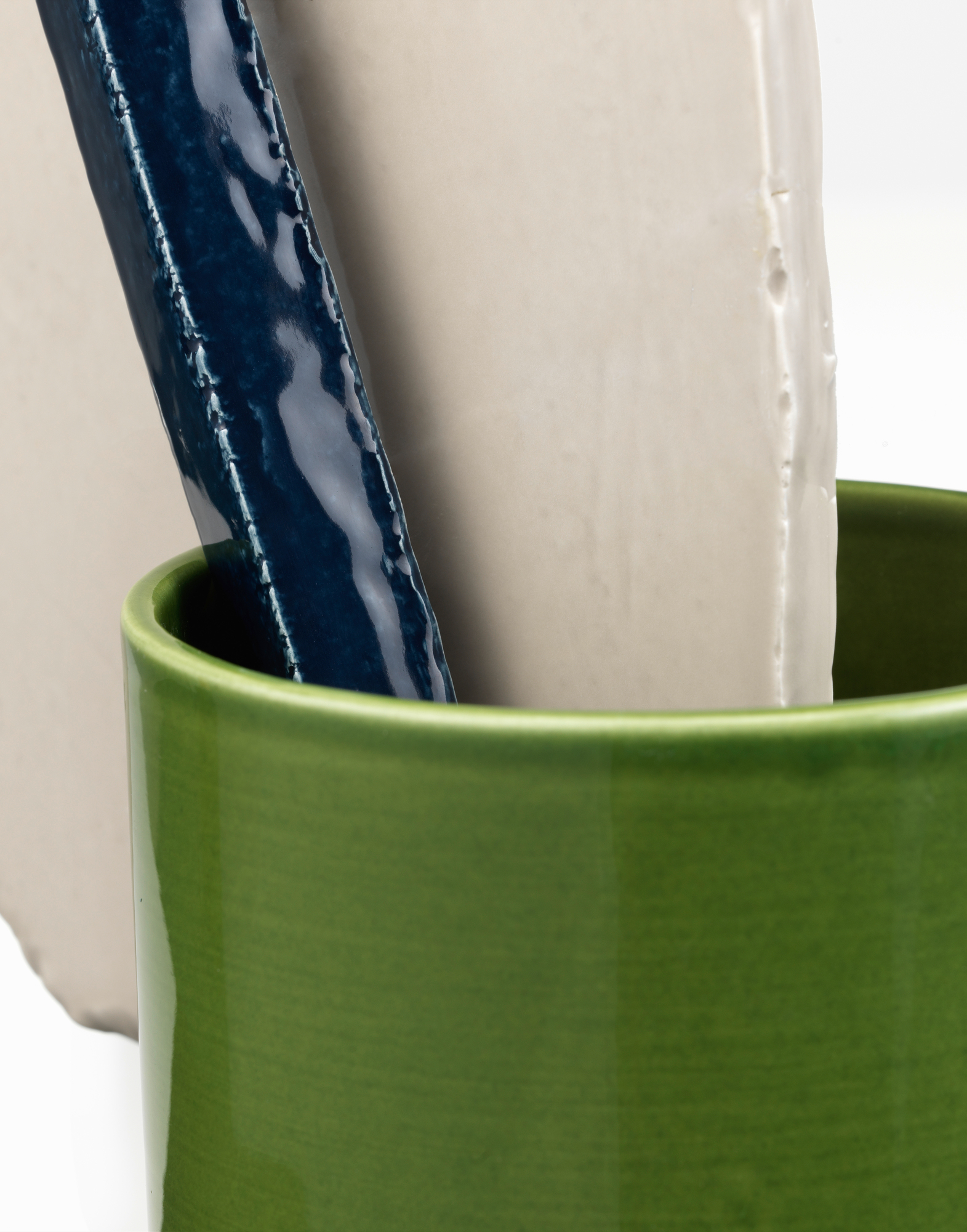 Vitra Découpage Vase: Detailaufnahme einer grünen Keramikvase mit blauen und beigen Dekorelementen.