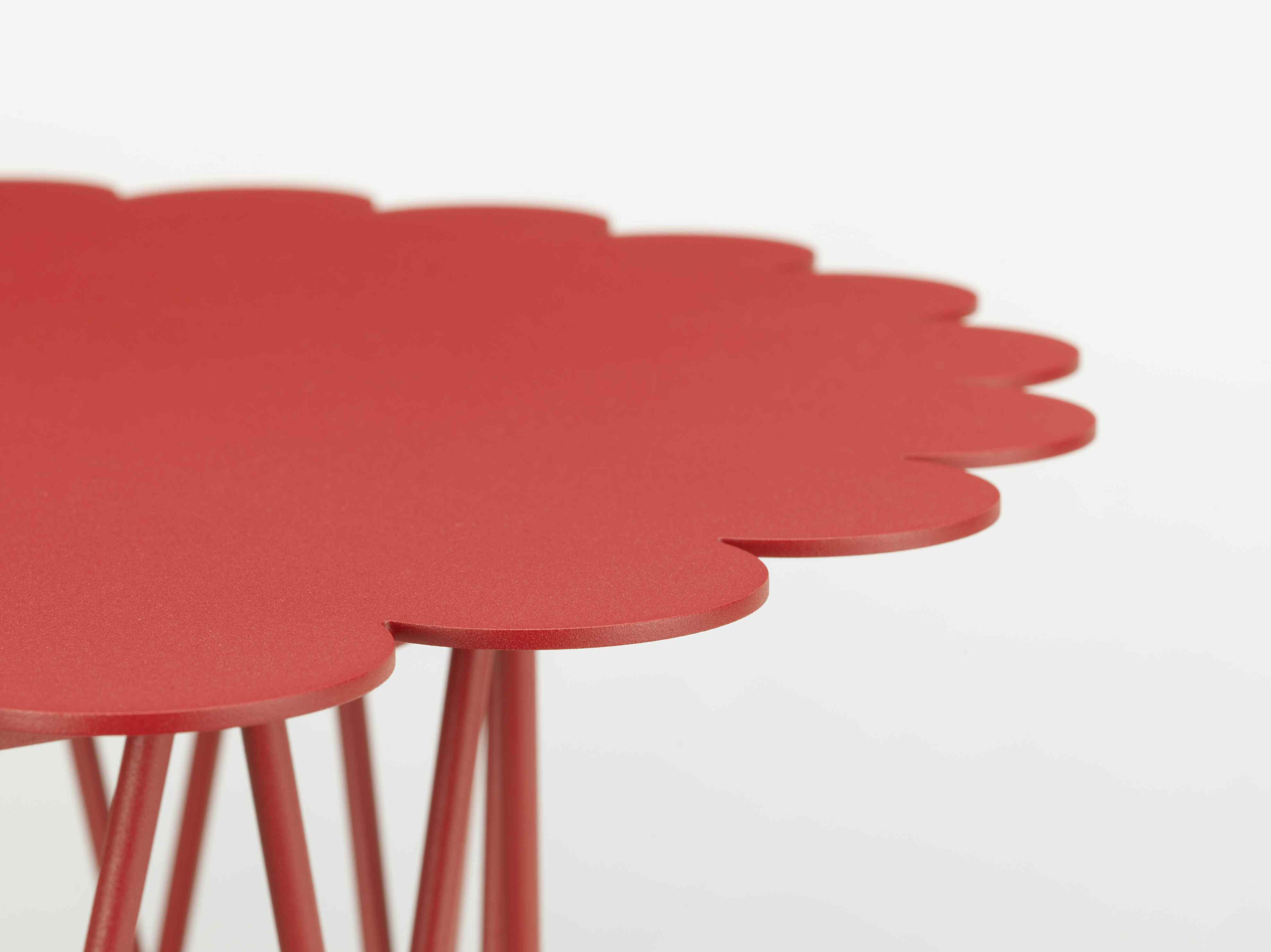 Detailaufnahme des roten Vitra Flower Table Beistelltisch mit blütenförmiger Tischplatte und filigranem Metallgestell.