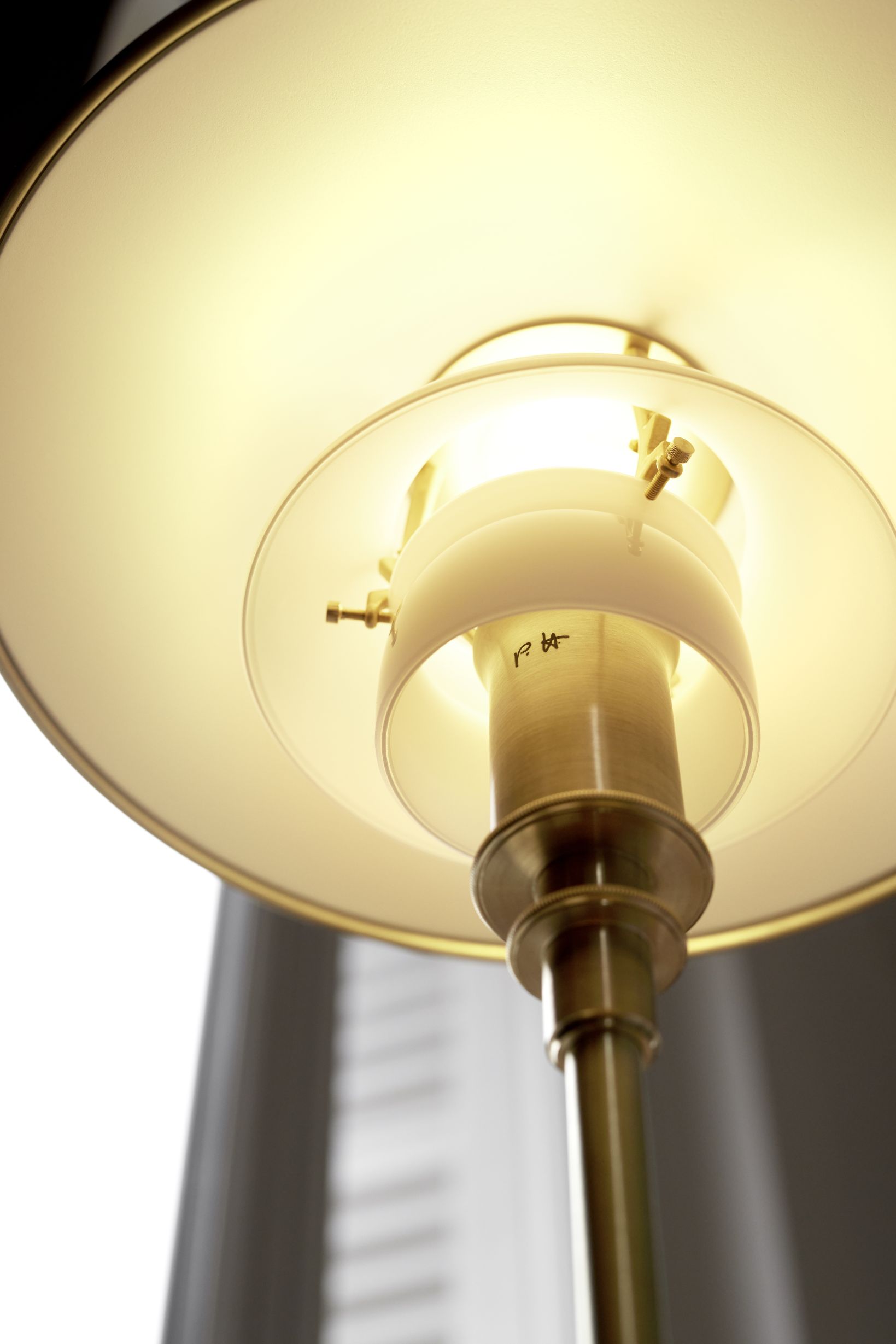 Detailaufnahme der PH 3/2 Tischleuchte aus Messing von Louis Poulsen. Designklassiker für stilvolle Beleuchtung.