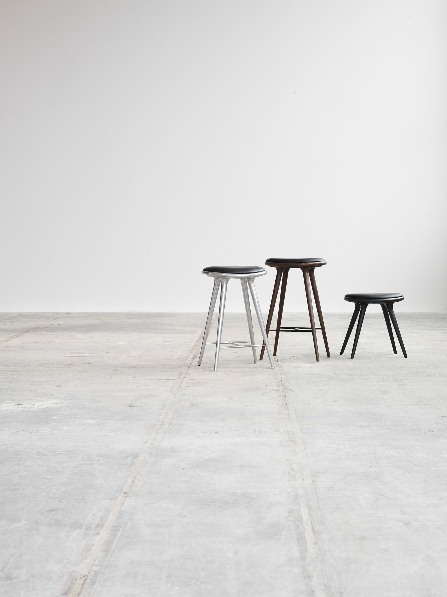 Drei Hocker: Aluminium Barhocker, Holz Hocker und kleiner schwarzer Hocker vor weißem Hintergrund.
