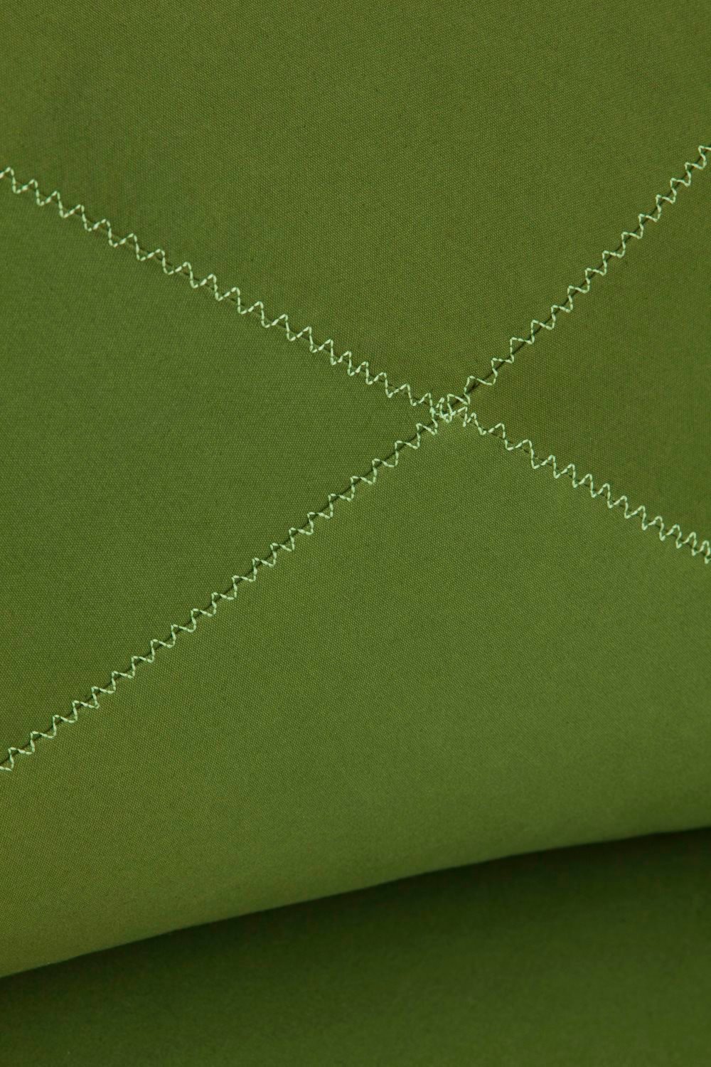 Detailaufnahme des grünen Grapy Sitzkissens aus Baumwolle mit Zickzack-Steppung. Gemütliches Kissen für Wohnzimmer und mehr.
