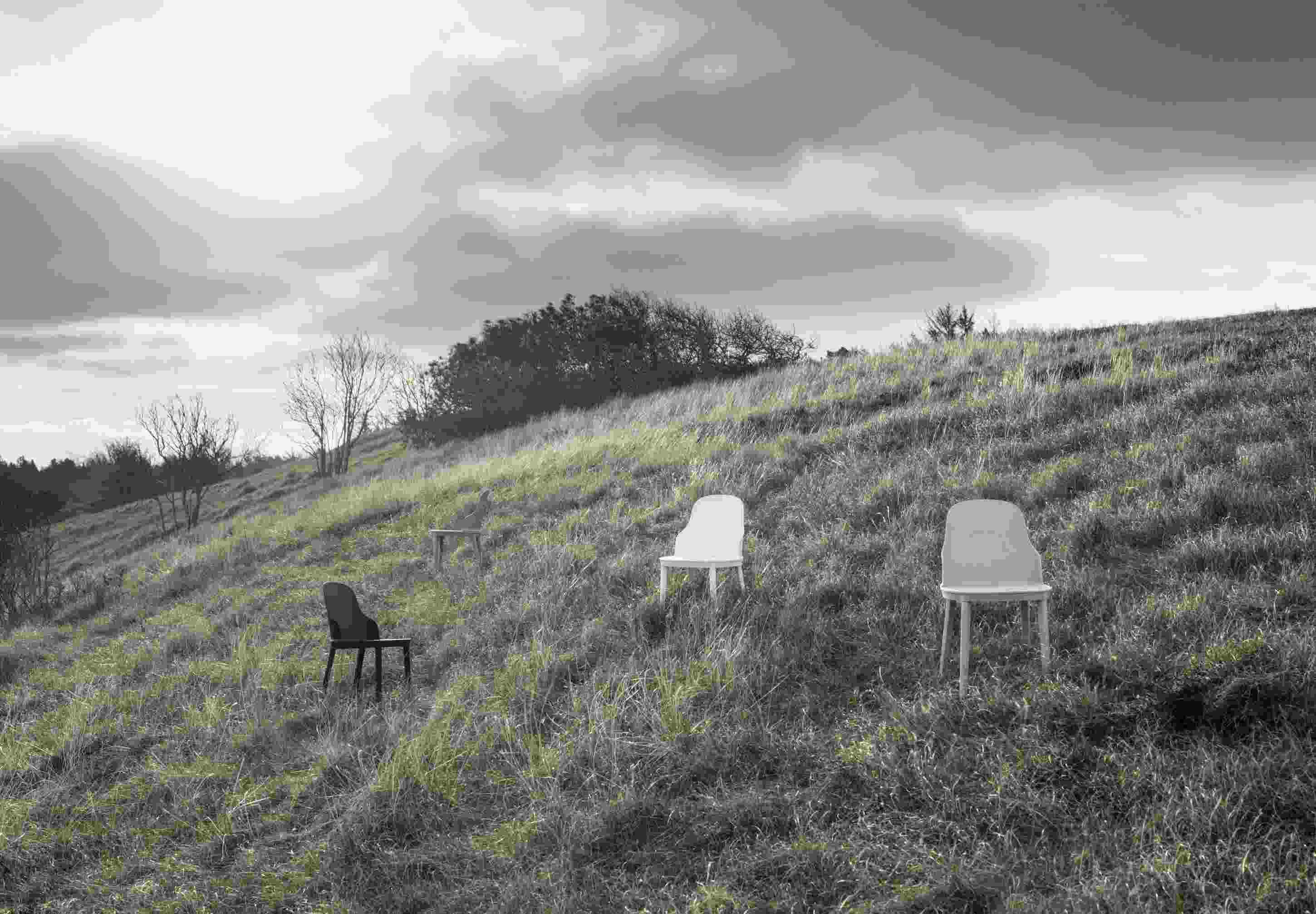 Drei Allez Stühle von Normann Copenhagen auf einer Wiese, minimalistisches Design, Outdoor-Möbel, moderner Gartenstuhl.