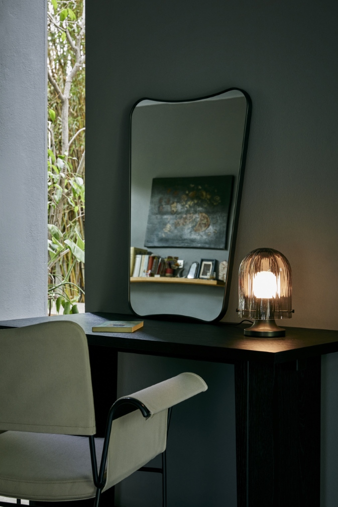 Schreibtisch mit Lampe, Spiegel und Stuhl. Elegante Tischleuchte mit geriffeltem Glas, modernes Design für Wohnzimmer und Büro.