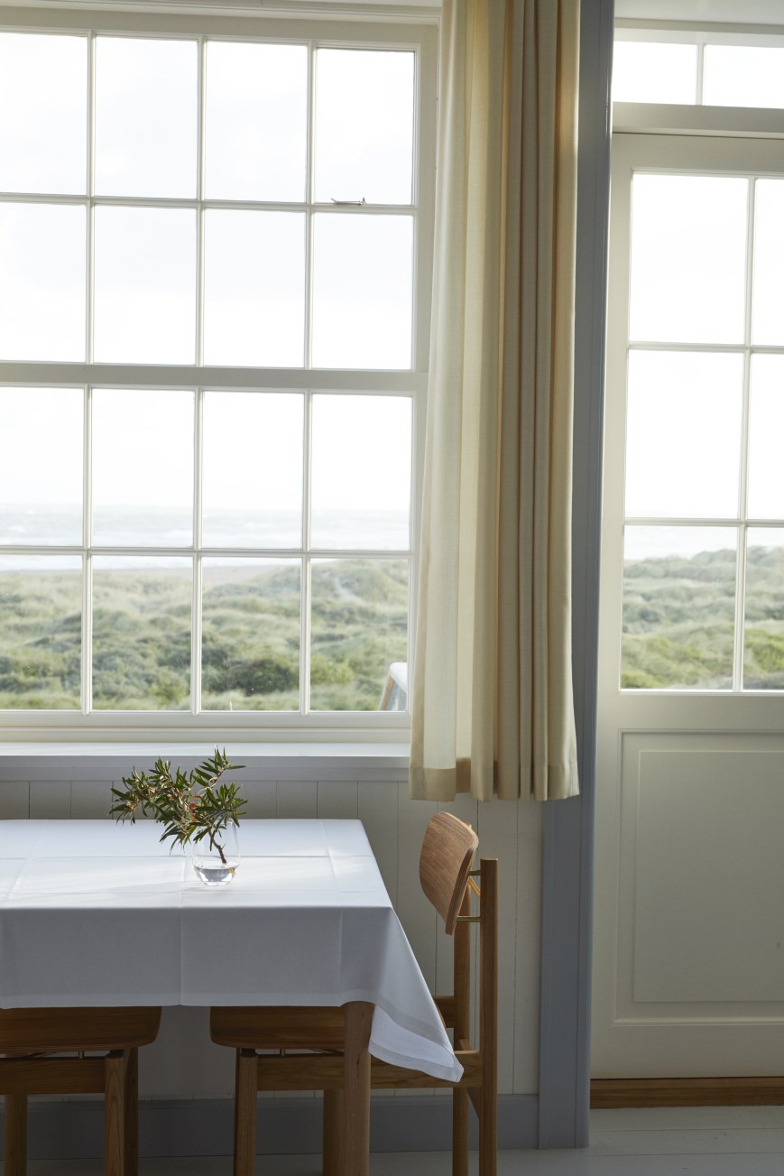 Vester Chair Stuhl von Skagerak by Fritz Hansen am Esstisch mit Meerblick.
