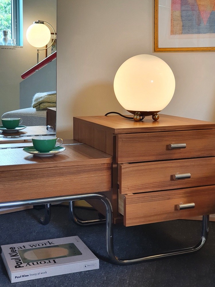 Art Déco Tischleuchte AD32 Tecnolumen mit runder, opalweißer Glaskugel auf Holzkommode. Design Lampe.