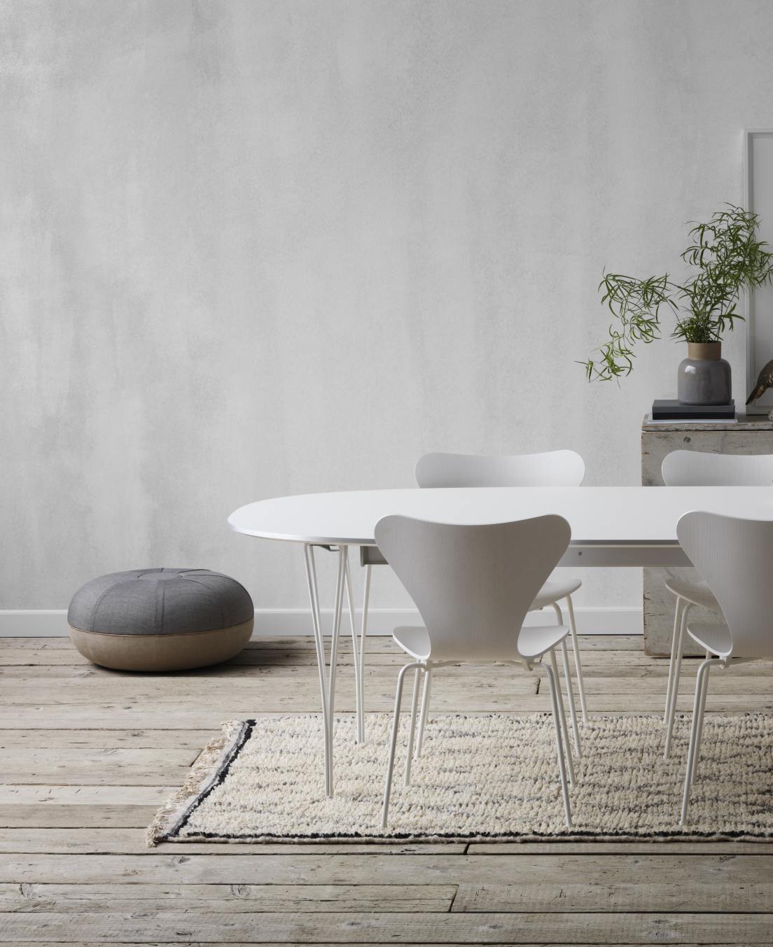 Weißer Super Elliptisch Ausziehtisch von Fritz Hansen mit Stühlen und Teppich auf Holzboden.