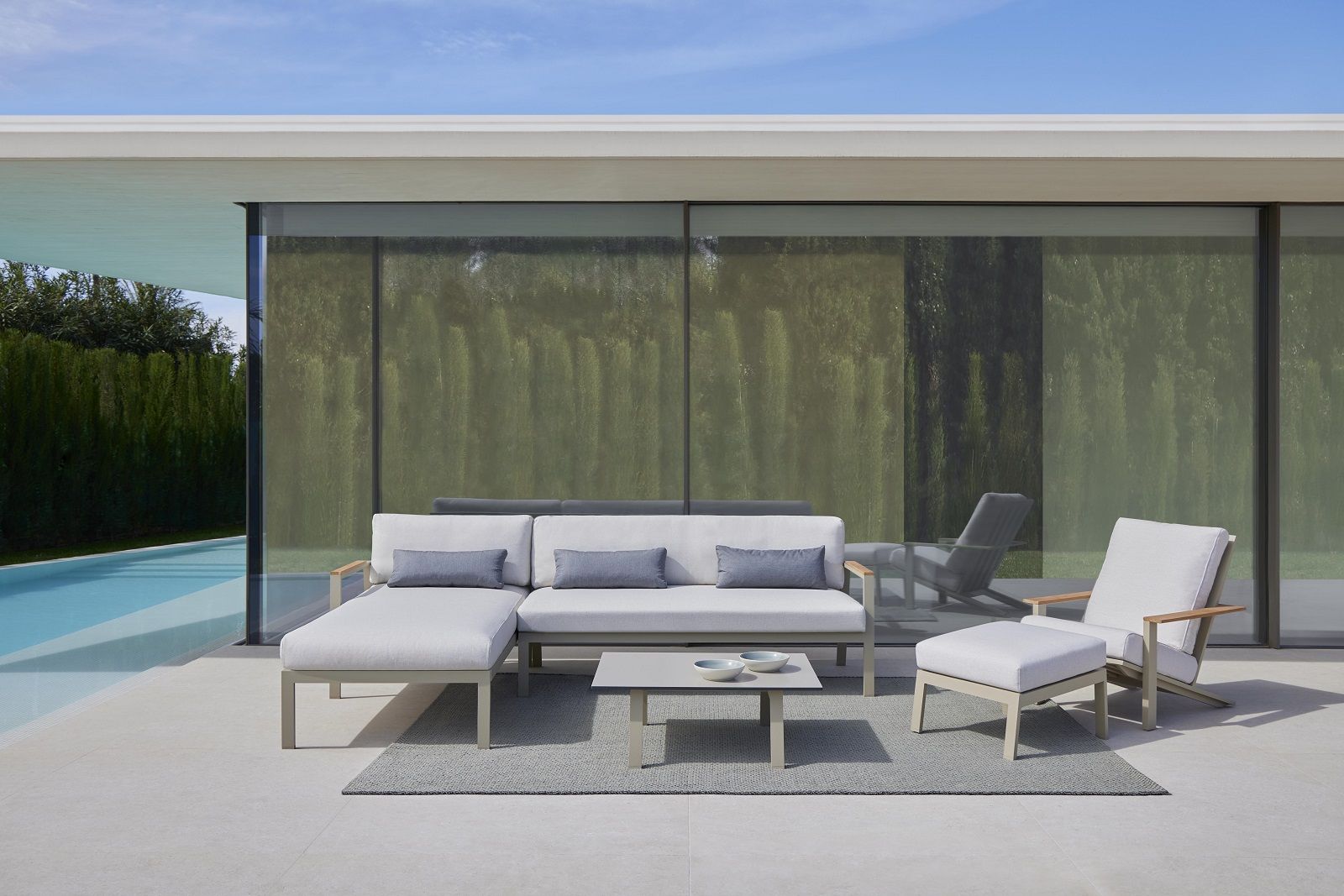 Saline Outdoor Rug Teppich von Gan auf einer Terrasse mit Loungemöbeln und Pool.