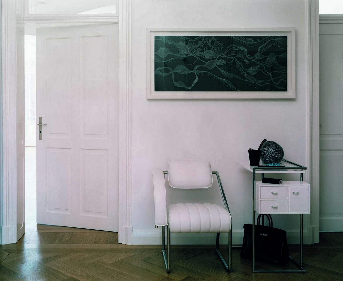Weißer Non Conformist Sessel von ClassiCon mit Chromgestell in einem hellen Raum. Designermöbel für stilvolles Wohnen.
