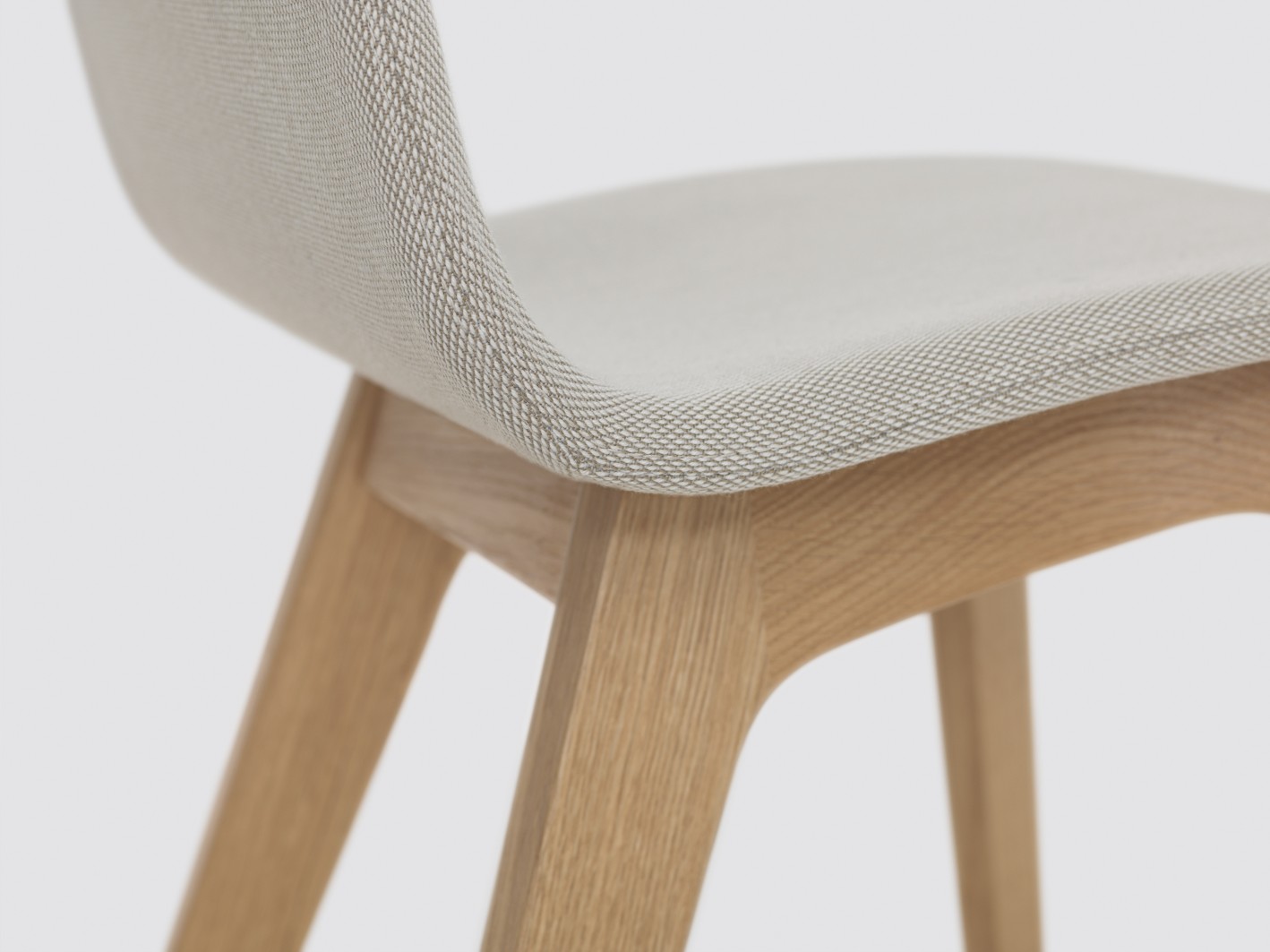 Detailaufnahme: Morph Stuhl mit Holzgestell und hellgrauer Vollpolsterung, modernes Design.
