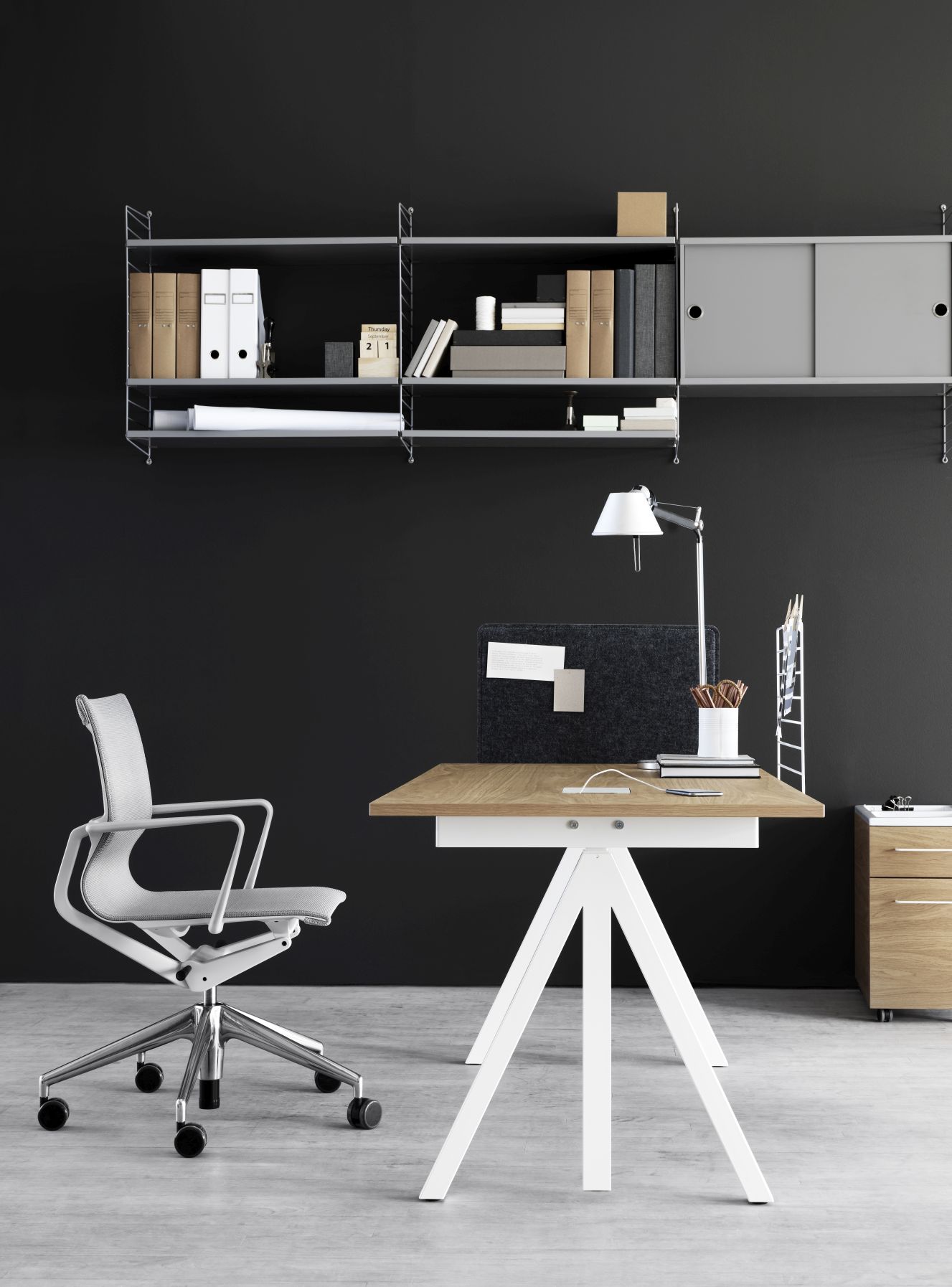 Moderner Schreibtisch mit Eichenplatte und weißem Gestell, Teil eines String Regalsystems im Büro.