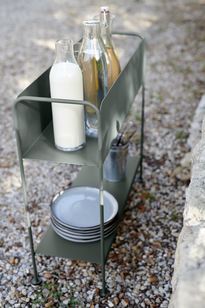 Picolino Servierwagen von Fermob in Moosgrau mit Getränken und Geschirr im Garten.