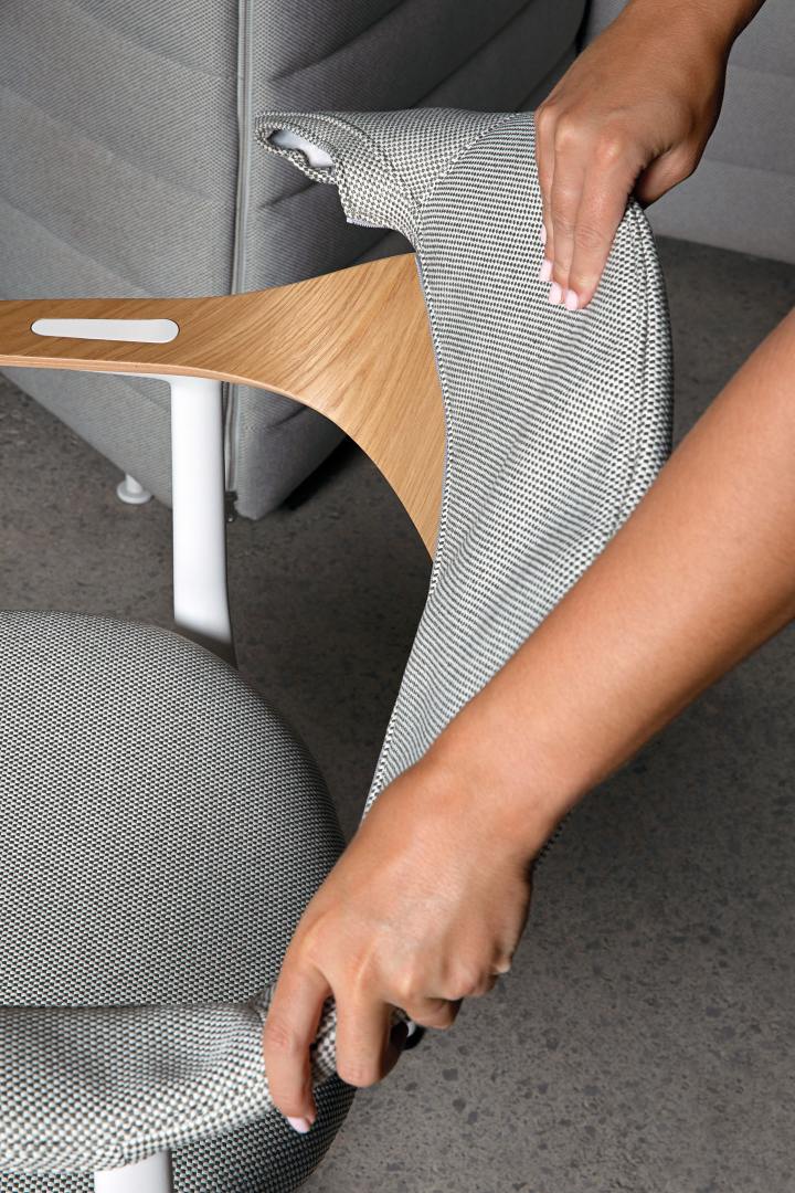 Detailaufnahme Mynt Bürodrehstuhl von Vitra mit Armlehne aus Schichtholz und grauem Bezugsstoff.