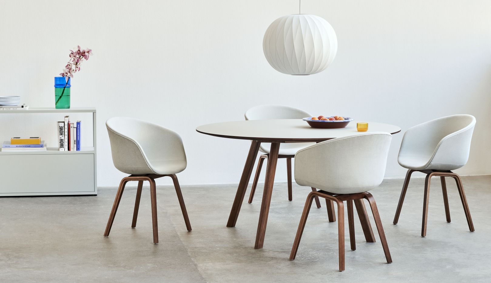 Heller Raum mit rundem Copenhague Table CPH 25 Tisch von Hay und vier weißen Stühlen.