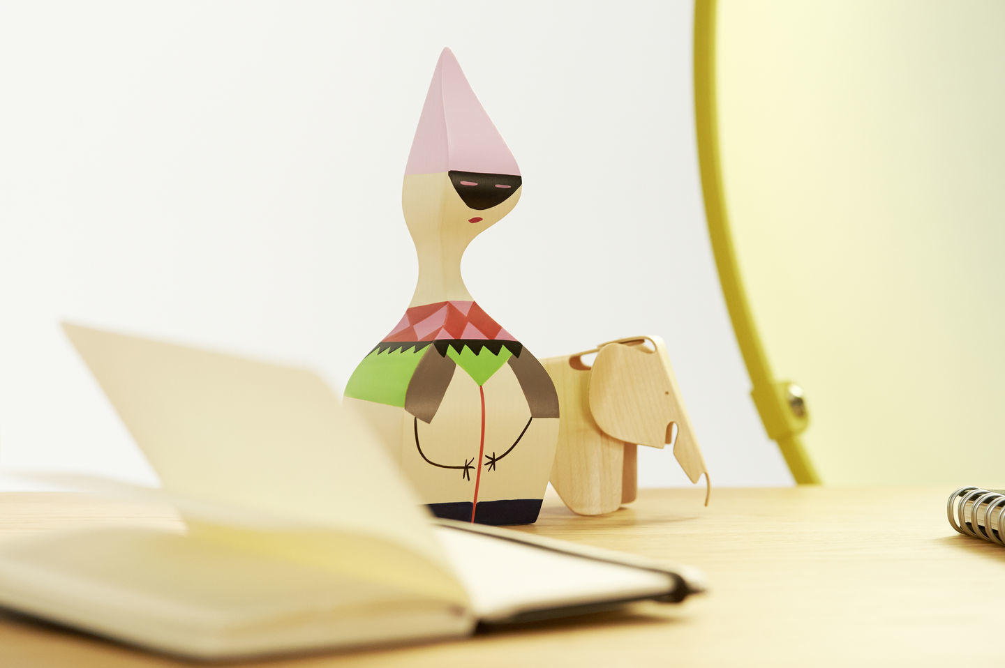 Vitra Wooden Doll Holzfigur mit Elefant auf einem Schreibtisch, Notizbuch im Vordergrund.