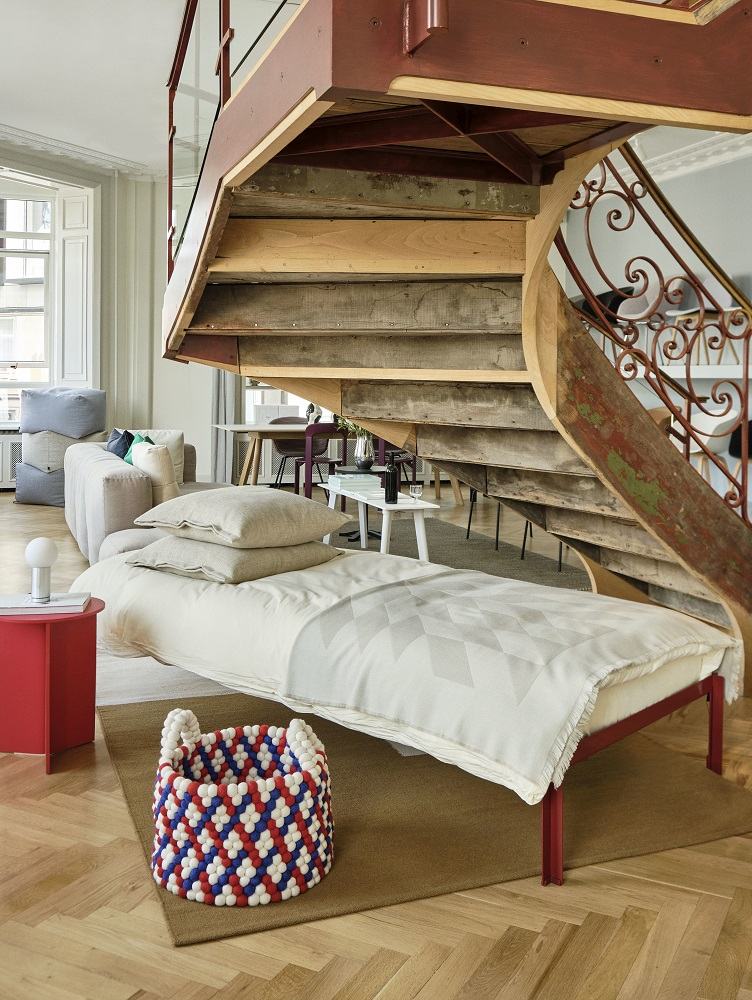 Bett mit Lattenrost und Bettwäsche unter einer Treppe. Standard Lattenroste für Betten.