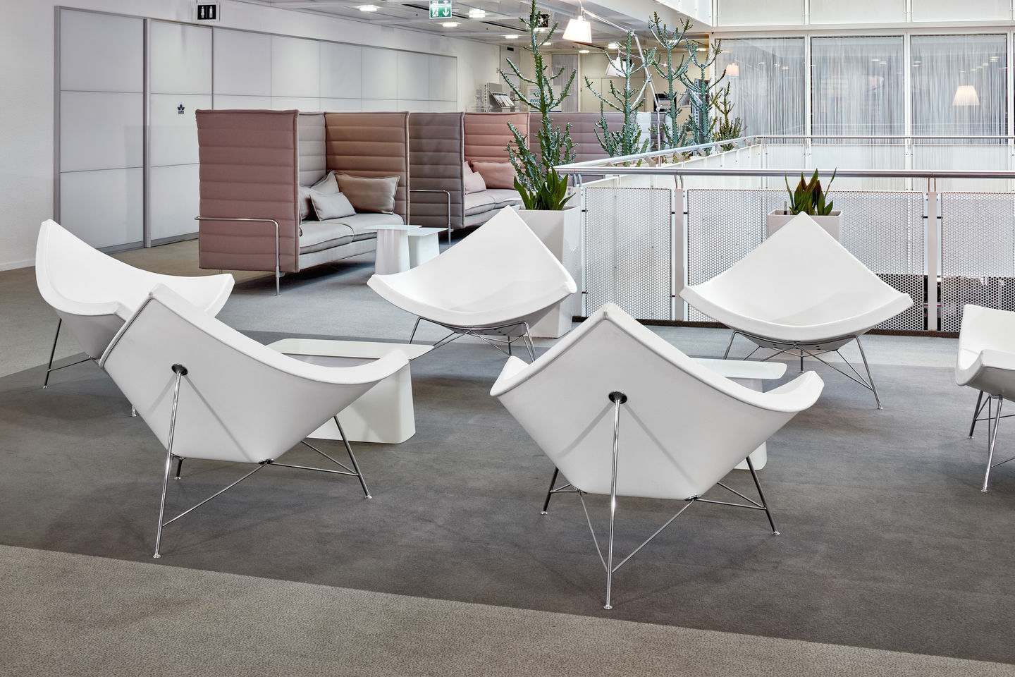Helle Büroumgebung mit mehreren weißen Coconut Chairs von Vitra und modernen Sitzecken.