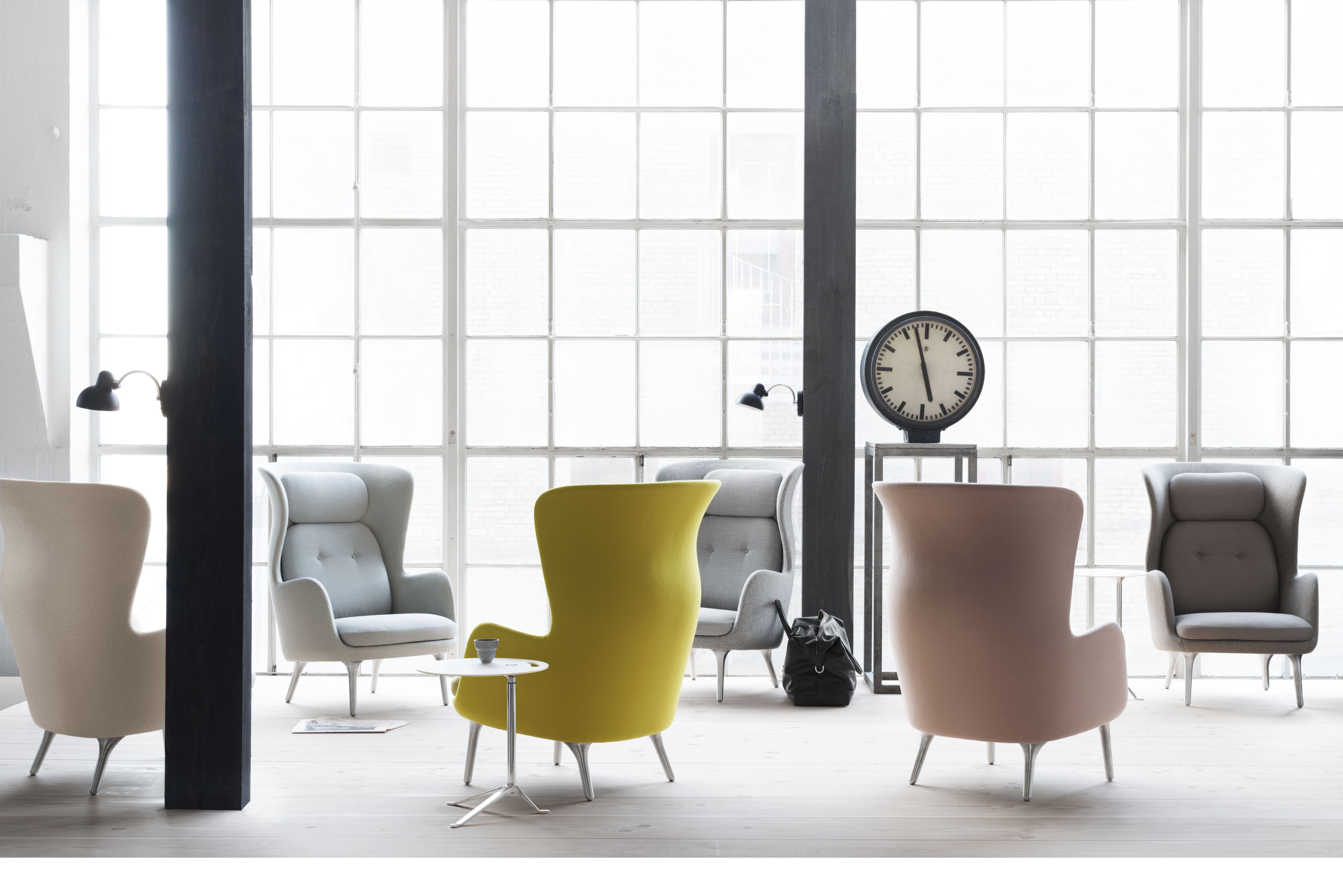 Ro Sessel von Fritz Hansen: Mehrere farbige Sessel mit Holzbeinen in einem hellen Raum.