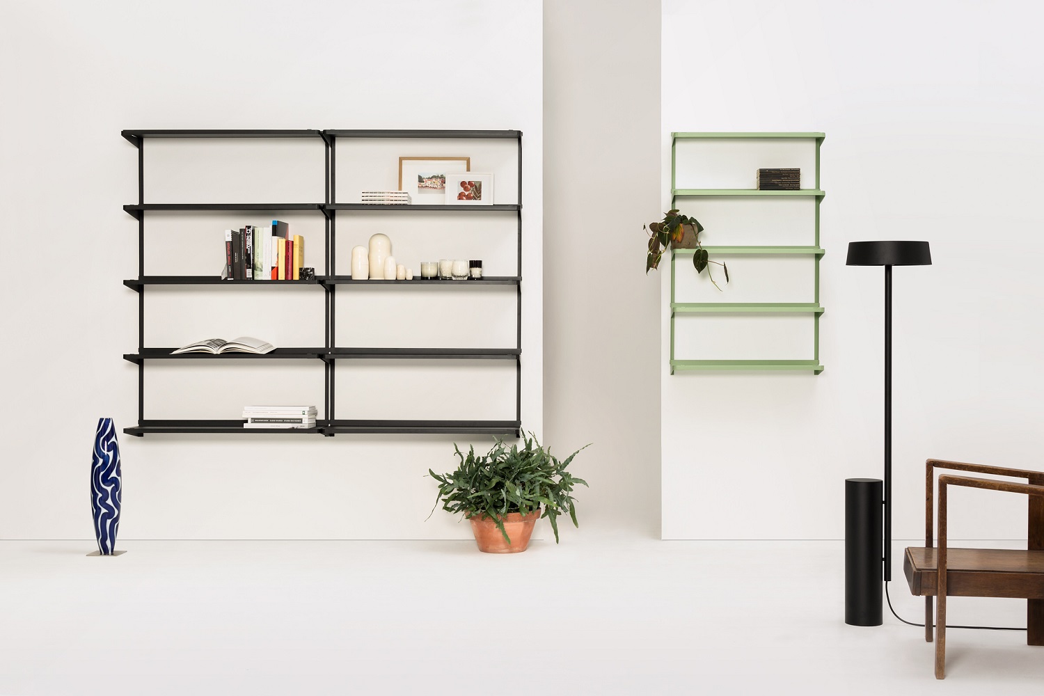Schwarzes Click Wandregal von New Tendency im minimalistischen Wohnzimmer mit Dekoration und grünen Akzenten.