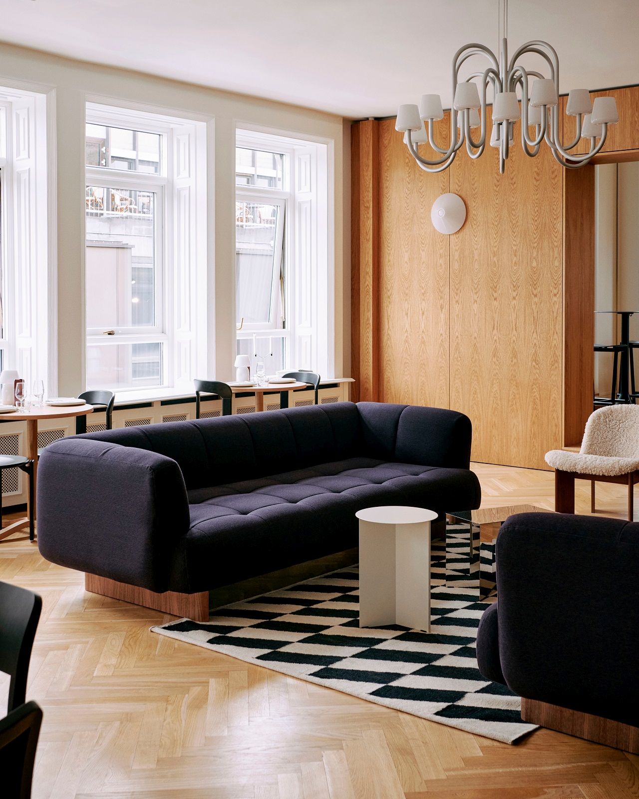 Wohnzimmer mit Sofa und Hay Kelim Rug Teppich in Schwarz-Weiß Schachmuster.