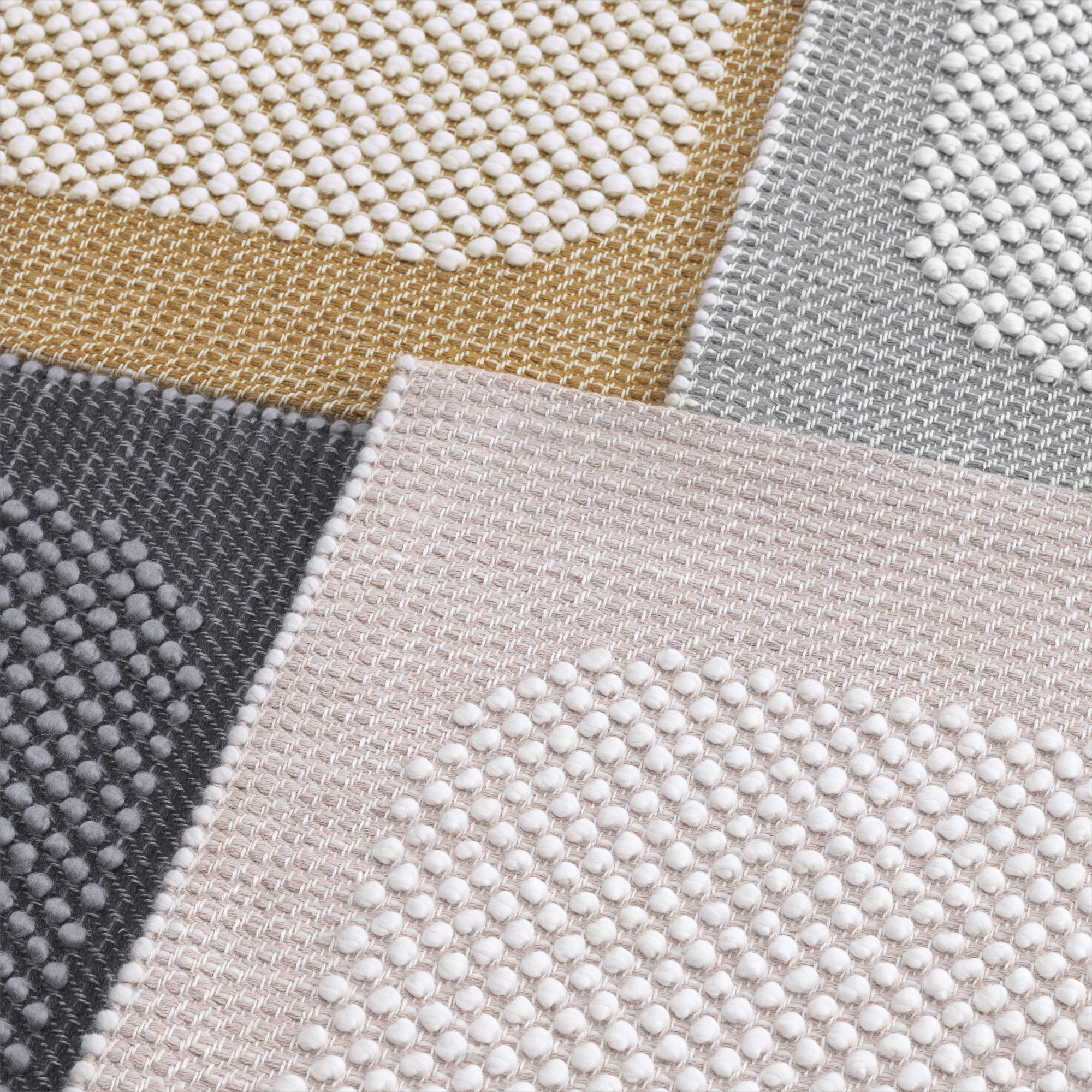 Detailaufnahme von verschiedenen Farbvarianten des Muuto Pebble Rug Teppichs mit dreidimensionaler Textur.