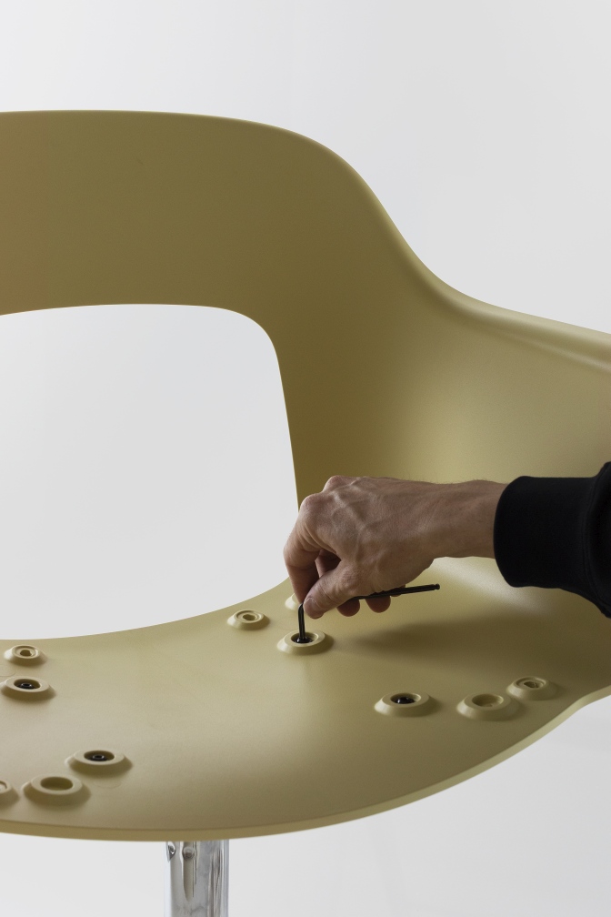 Aufbau des Hay Layout Armchair 232: Nahaufnahme einer Hand, die eine Schraube festzieht.