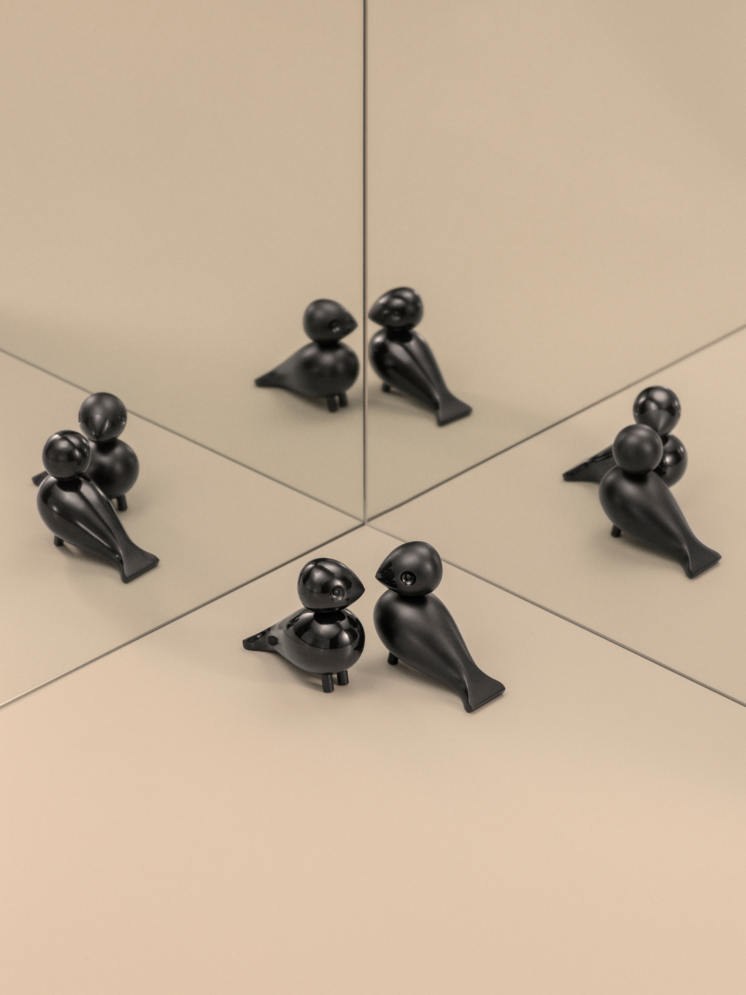 Kay Bojesen Unzertrennliche Lovebirds, schwarze Holzfiguren, dekorative Designobjekte, reflektiert in Spiegelflächen, skandinavisches Design.