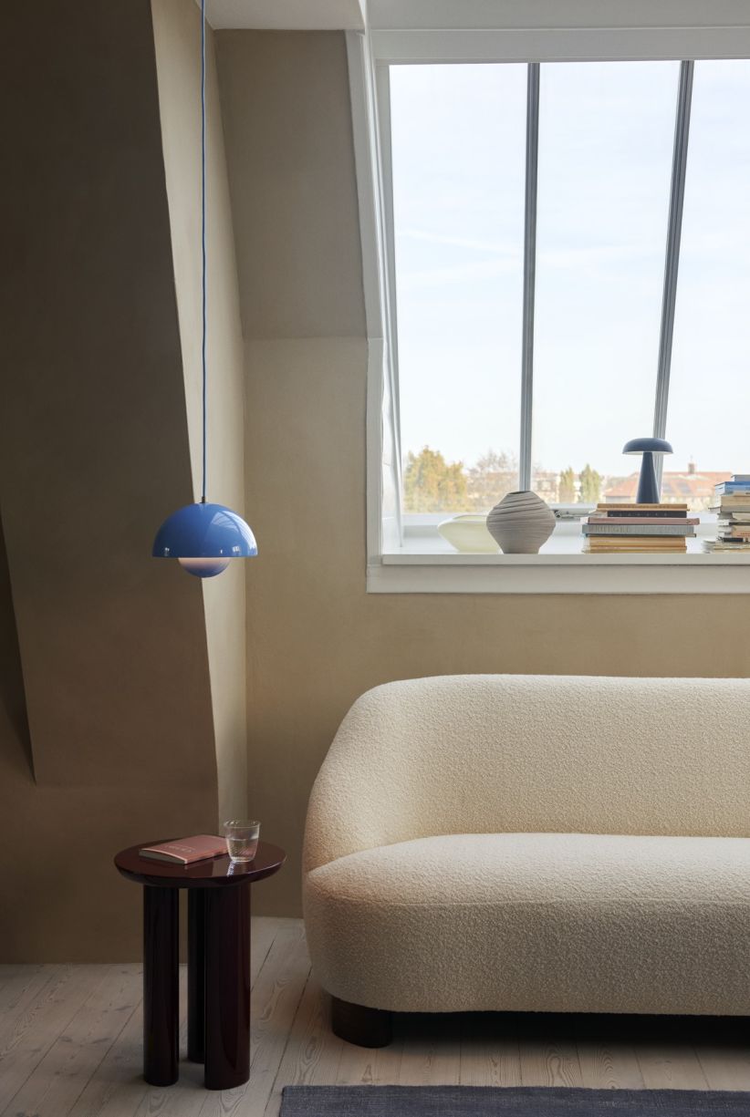 Blaue VP1 Flowerpot Pendelleuchte von AndTradition über kleinem Tisch in modernem Wohnzimmer mit Sofa.