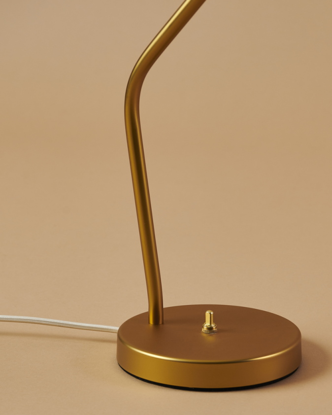 Detailaufnahme der goldenen Gräshoppa Tischleuchte von Gubi, Fokus auf Fuß und Schalter. Design-Klassiker für Schreibtisch und Büro.