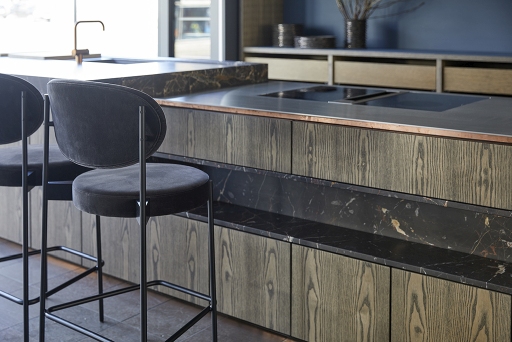 Schwarzer Series 430 Bar Stool Barhocker mit Samtbezug vor einer modernen Kücheninsel mit Marmor.