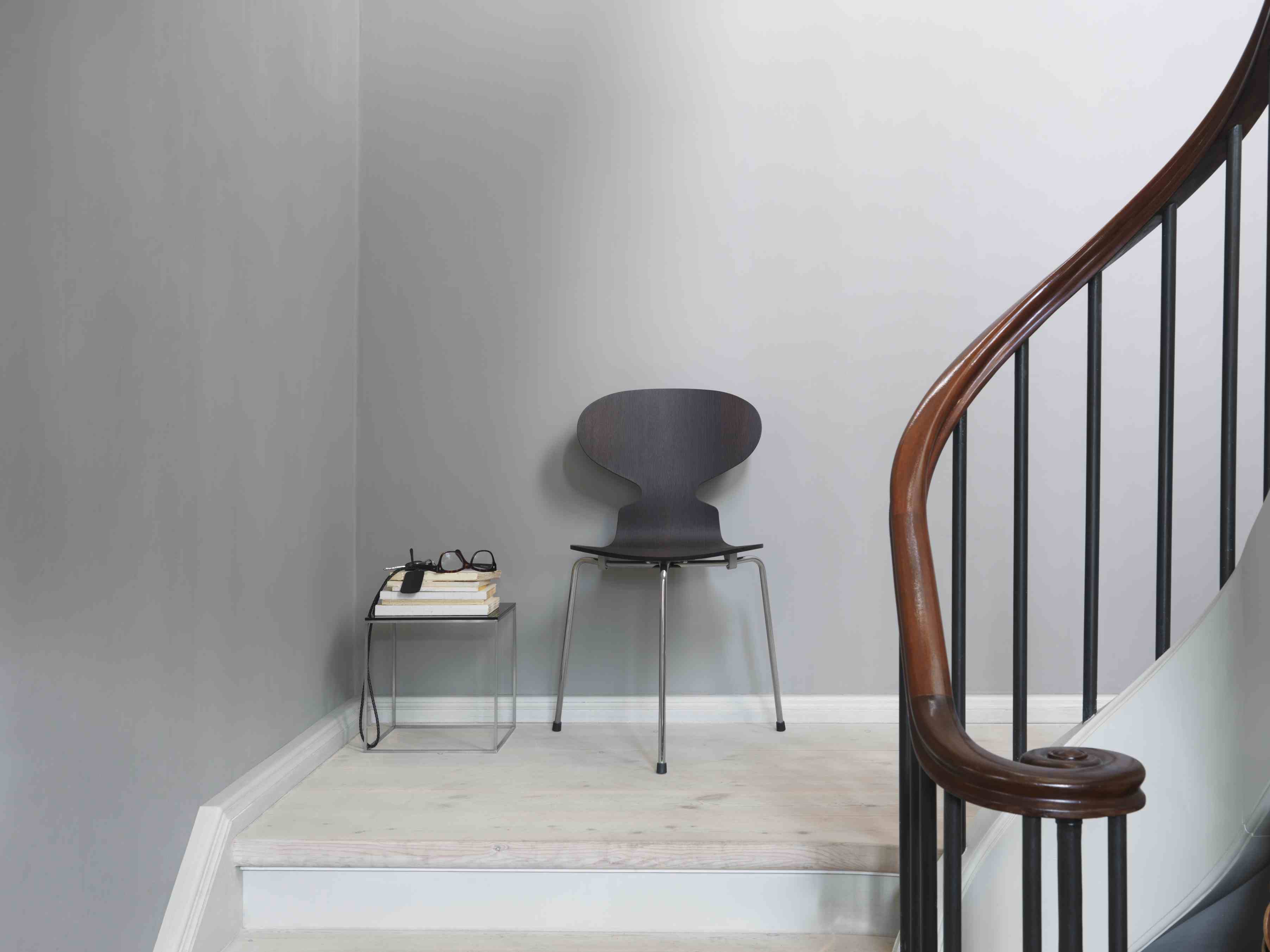 Die Ameise Stuhl von Fritz Hansen mit 3-Bein Gestell in dunklem Holz auf Treppe.
