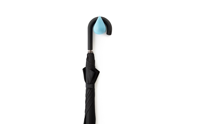 Nahaufnahme eines schwarzen Regenschirms, der an einem blauen Dropit Haken von Normann Copenhagen hängt.