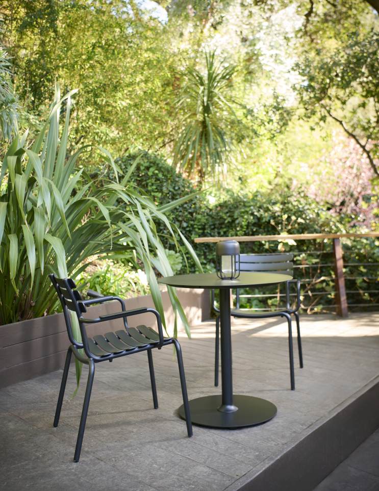 Alua Armrest Dining Chair: Schwarzer Armlehnstuhl aus Metall mit passendem Tisch für den Garten.