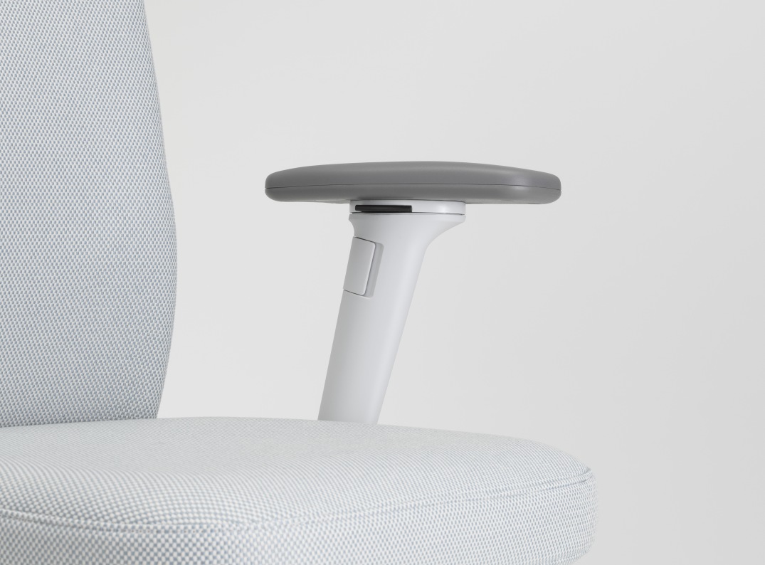 Detailaufnahme des Vitra ID Chair Soft Bürodrehstuhls mit grauen Armlehnen und hellgrauem Stoffbezug.