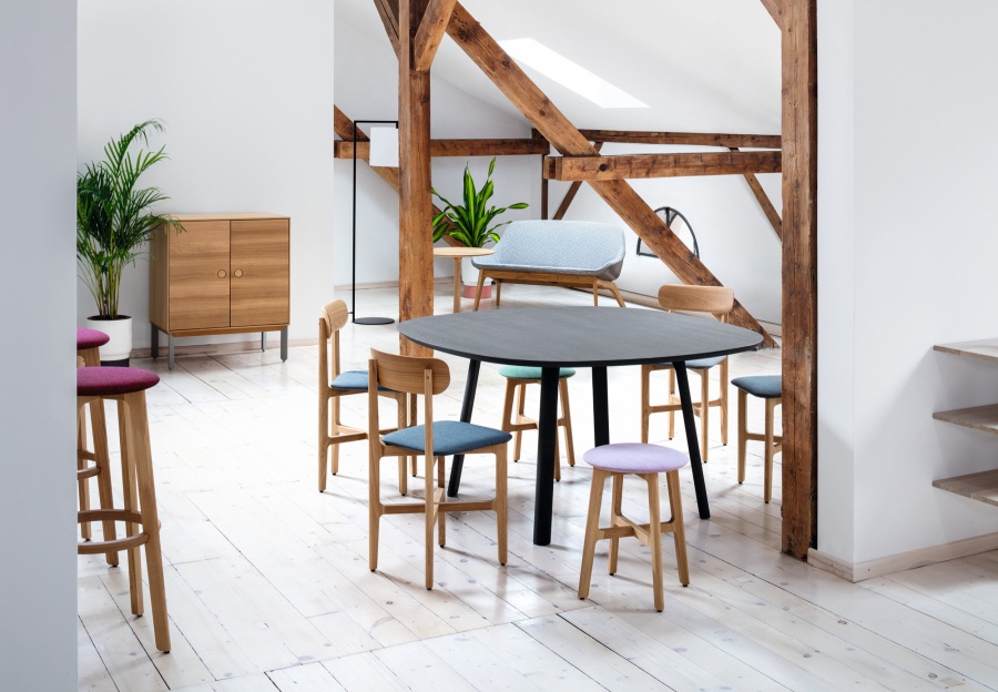 Helles Dachgeschoss mit Esstisch, Stühlen, Barhockern und Holzschrank. Modernes Möbeldesign für Esszimmer und Wohnbereich.