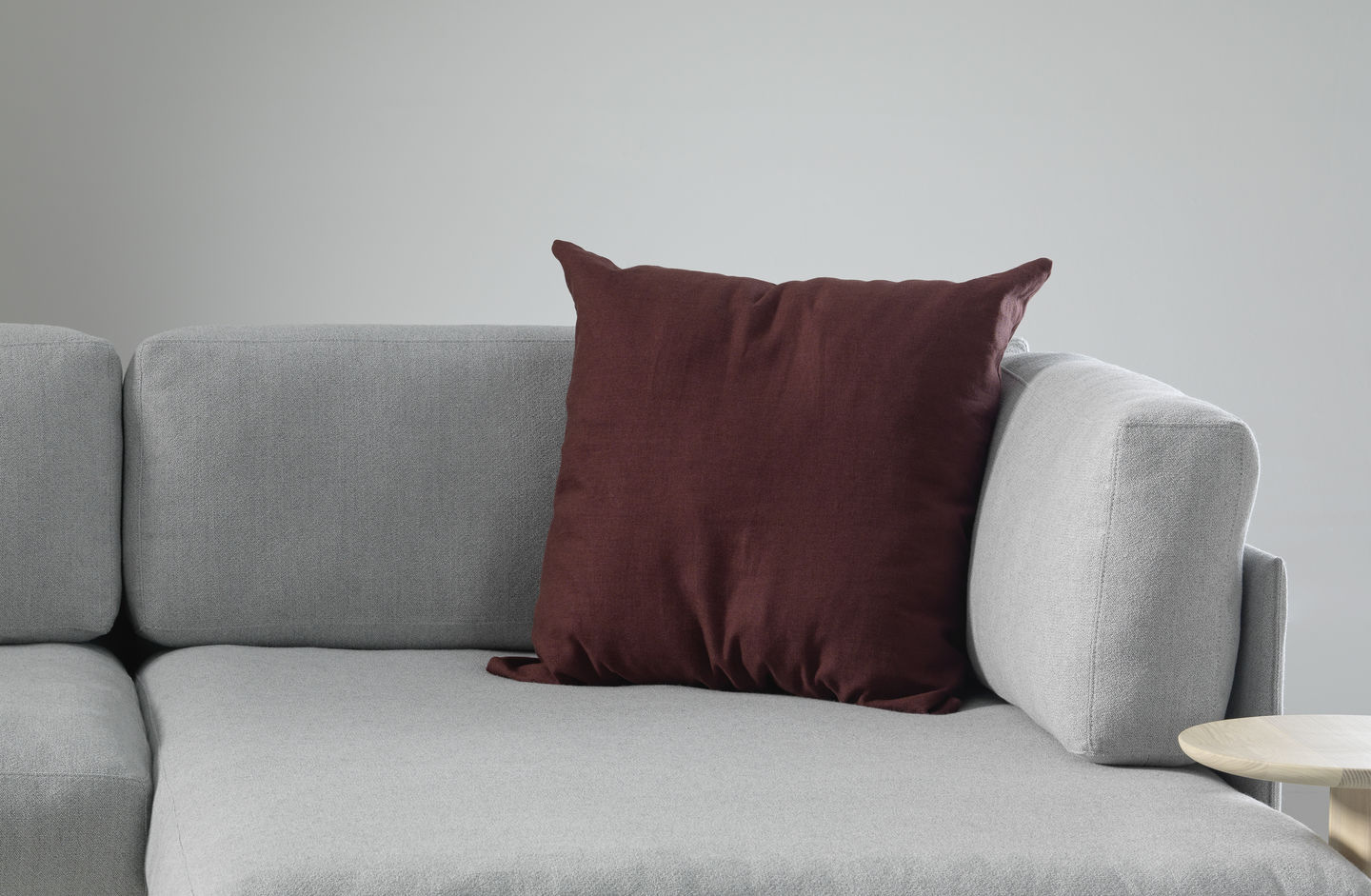 Vitra Cushions Kissen in Bordeaux auf einem grauen Sofa, modernes Wohnaccessoire für stilvolles Wohnen.
