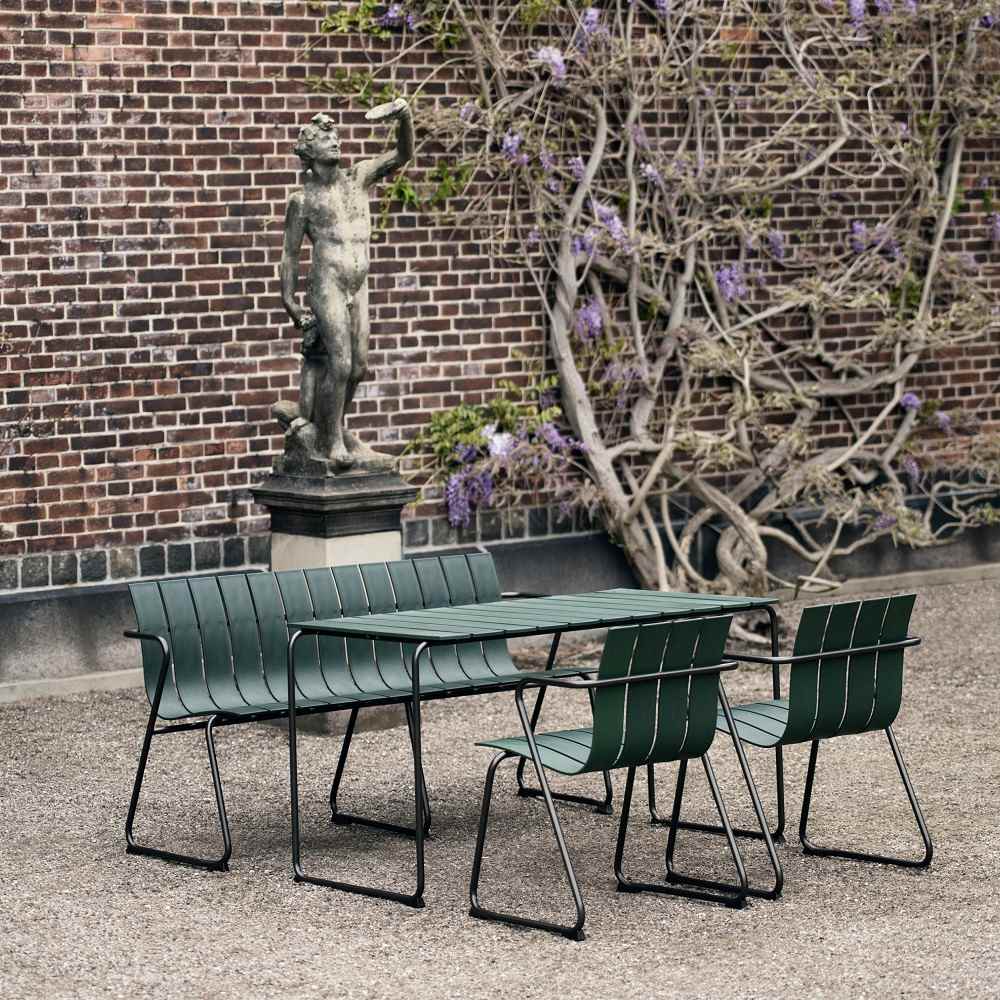 Grüne Ocean Bench Outdoor Bank von Mater OC2 mit Tisch und Stühlen im Garten.